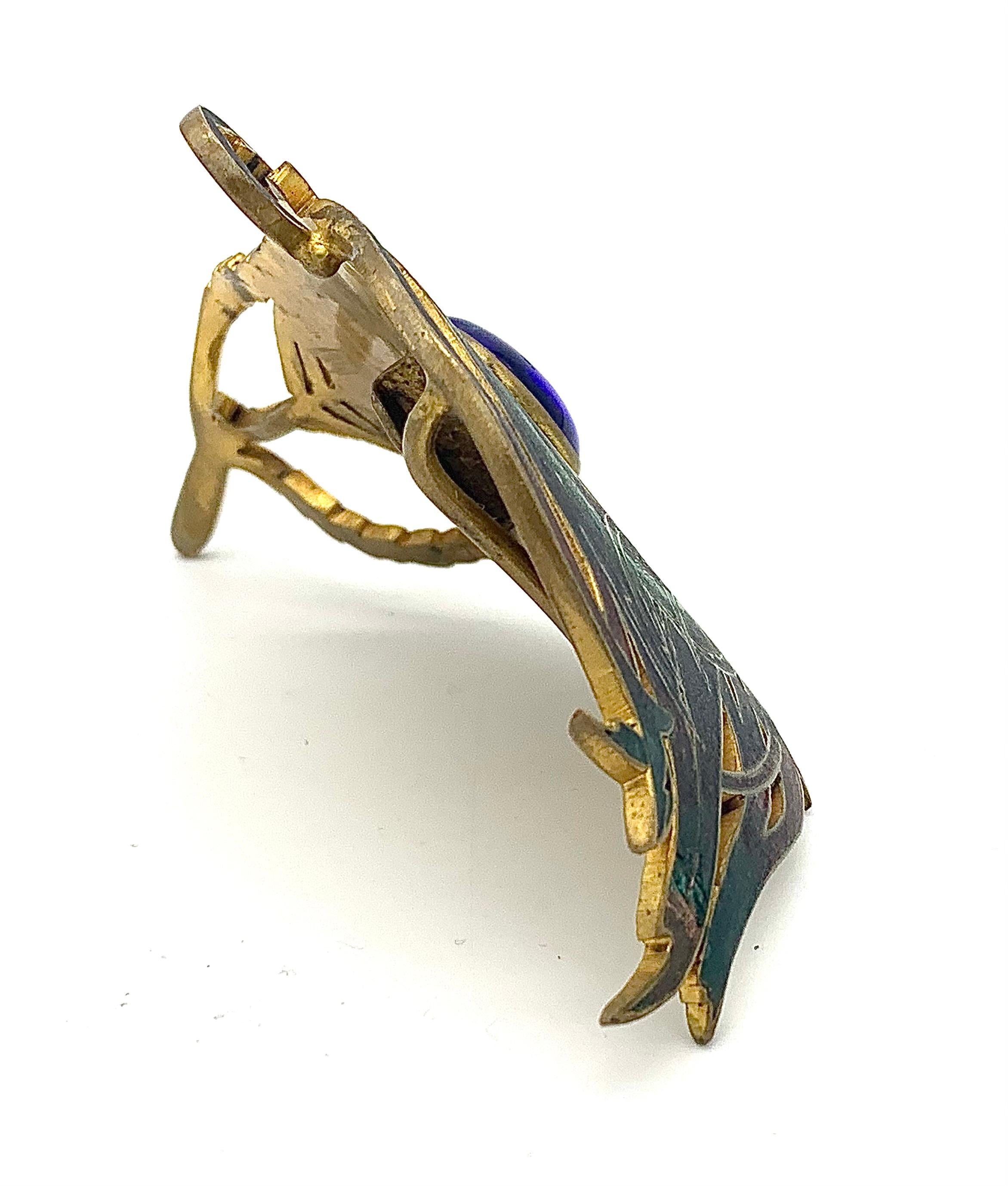 Cette remarquable boucle Art nouveau en forme de plume de paon a été conçue et exécutée par Piel Frères, Paris vers 1900.  
Une boucle identique est publiée dans le livre de Vivienne Becker 