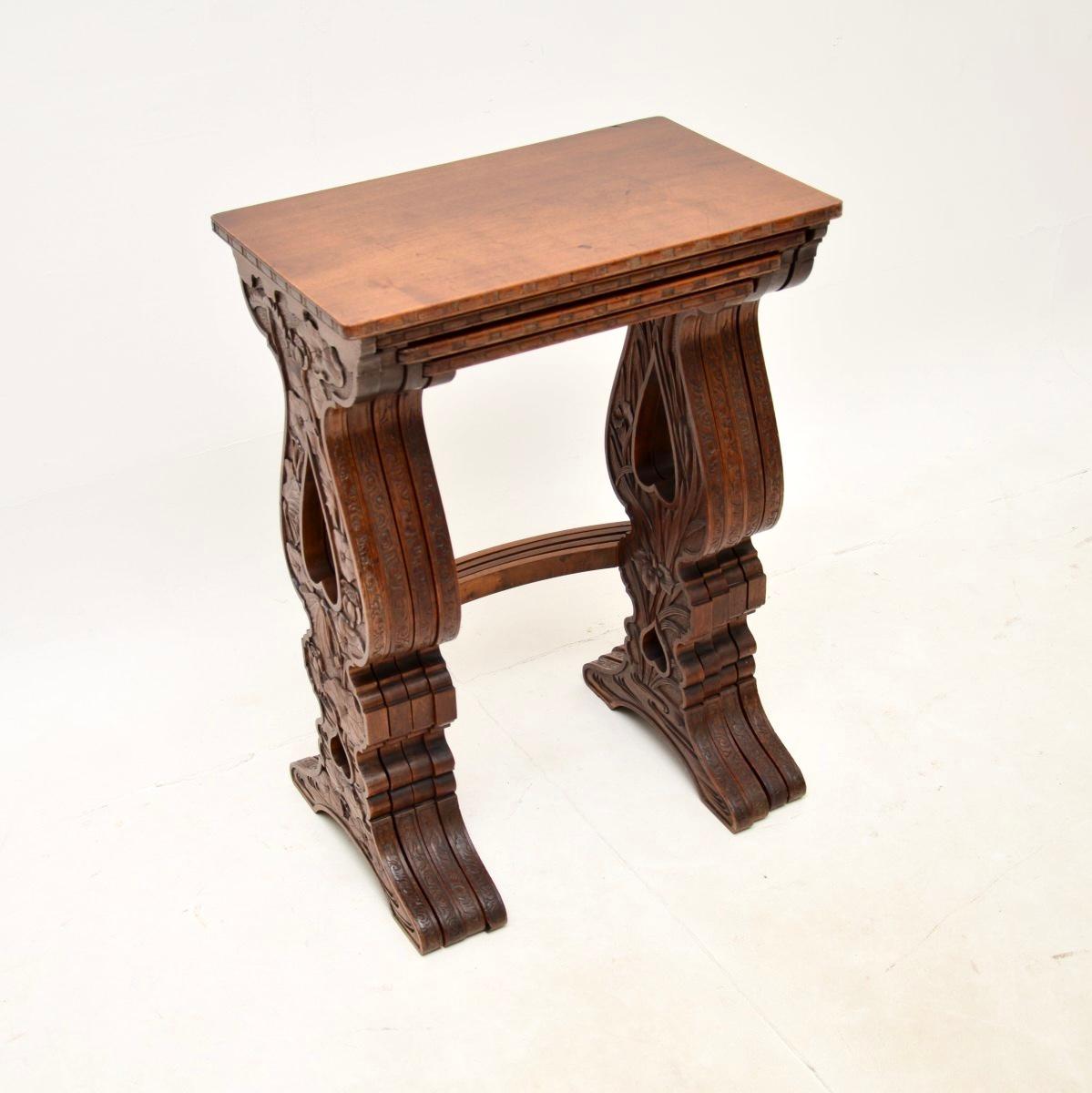 An absolutely stunning antique Art Nouveau carved nest of four tables. They were made in England, they date from around the 1890-1900 period.

The quality is outstanding, each of the four tables has unique botanical themed carving on the outer and