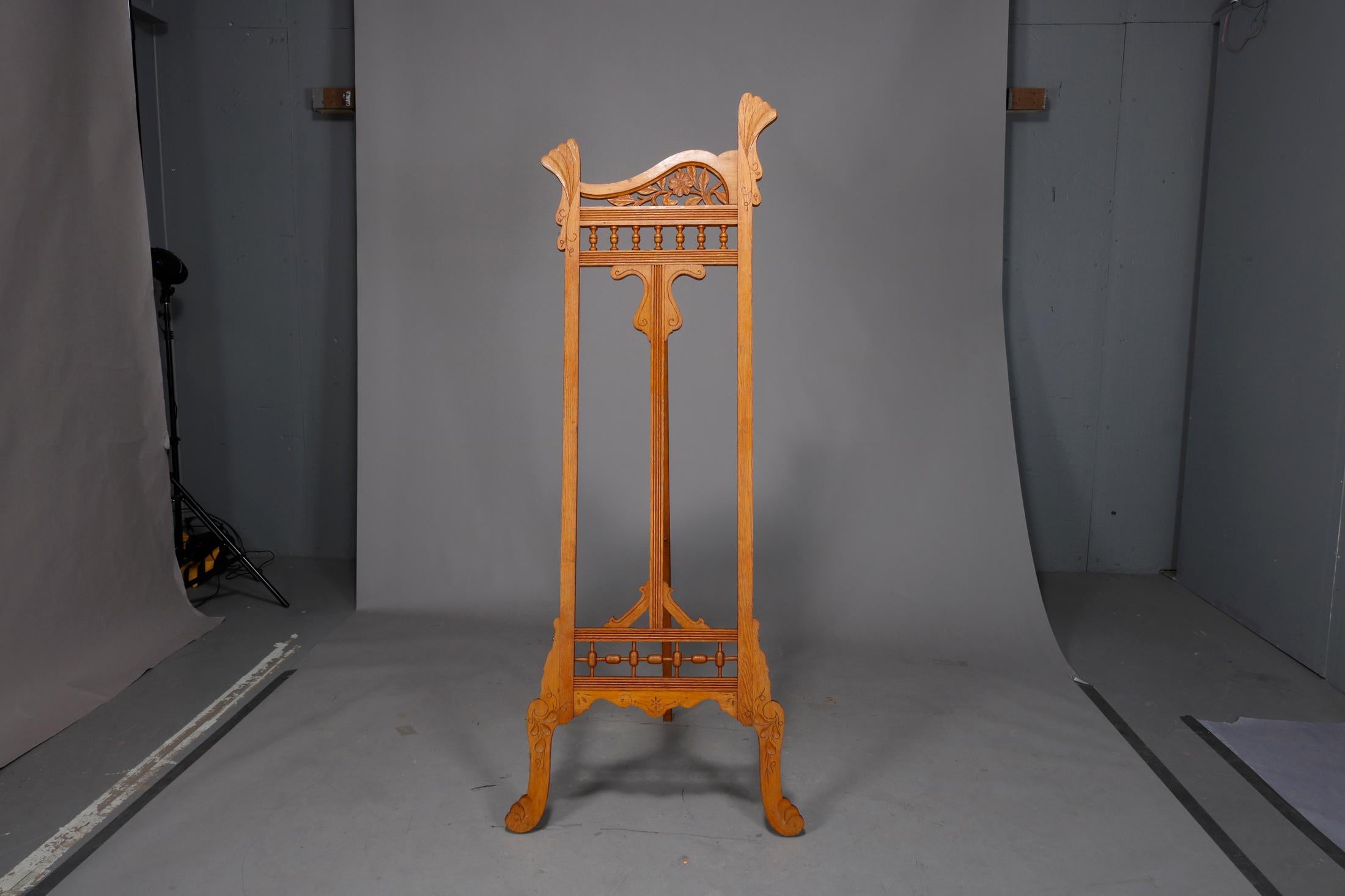 An antique Art Nouveau art display easel offers oak construction with shaped crest having pierced floral elements, base with stick and ball rail, raised on cabriole legs, circa 1900

Measures: 74