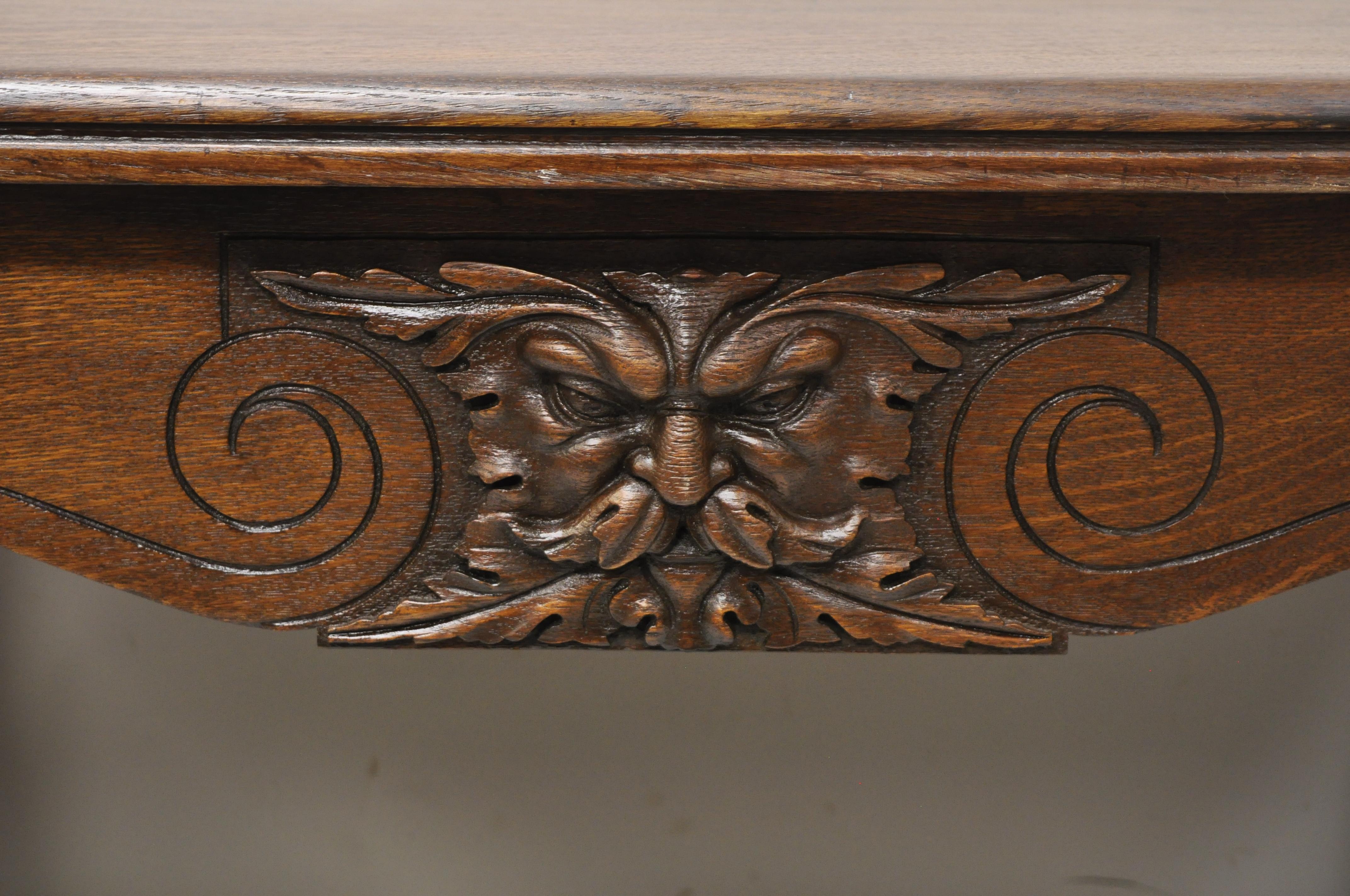 Ancienne table bibliothèque de bureau en bois de chêne sculpté Art Nouveau anglais avec un tiroir. Cet article présente des visages de Northwind sculptés à l'avant et à l'arrière, des supports d'angle en laiton, une construction en bois de chêne
