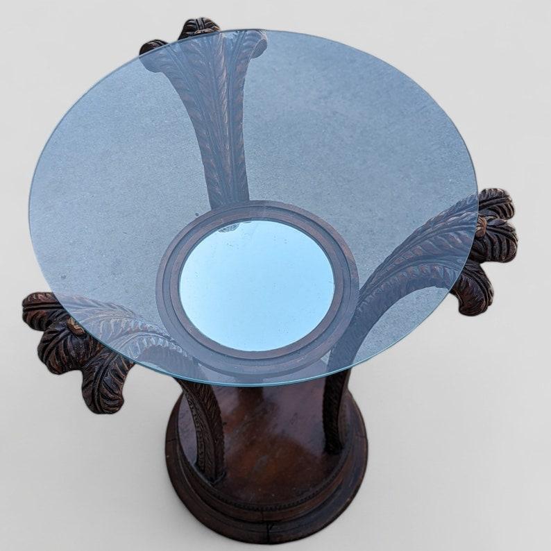 This antique side table features a beautifully crafted wood base, adding a touch of elegance and sophistication to any living space. The intricate details and carved accents on the wooden base make it a unique and stylish piece that will complement