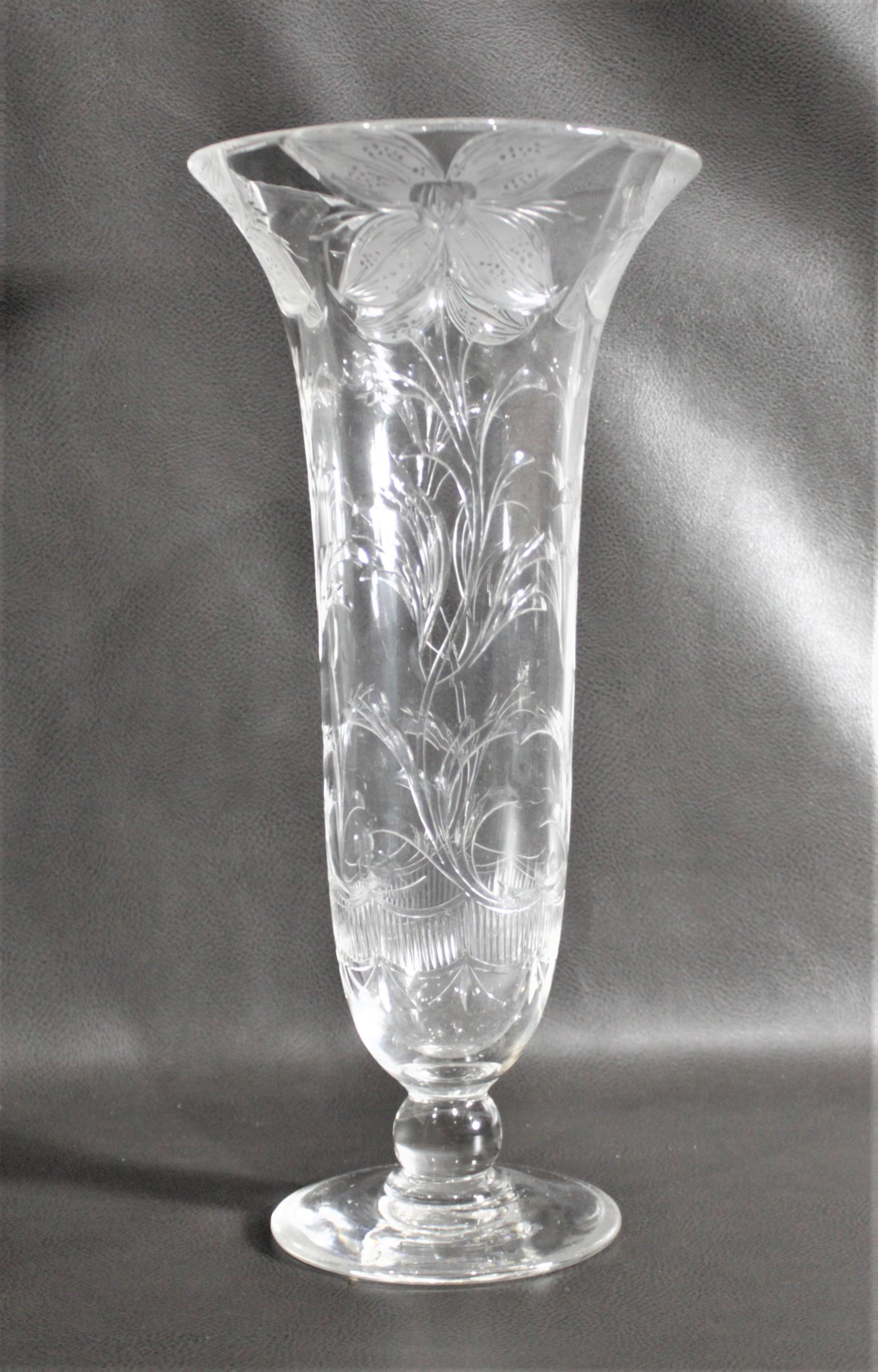 This tall cut crystal antique vase has no maker's marks but presumed to have been made in England in circa 1900 in the period Art Nouveau style. The vase stands over a foot tall and has a very elegant stylized four petal flower pattern repeated four