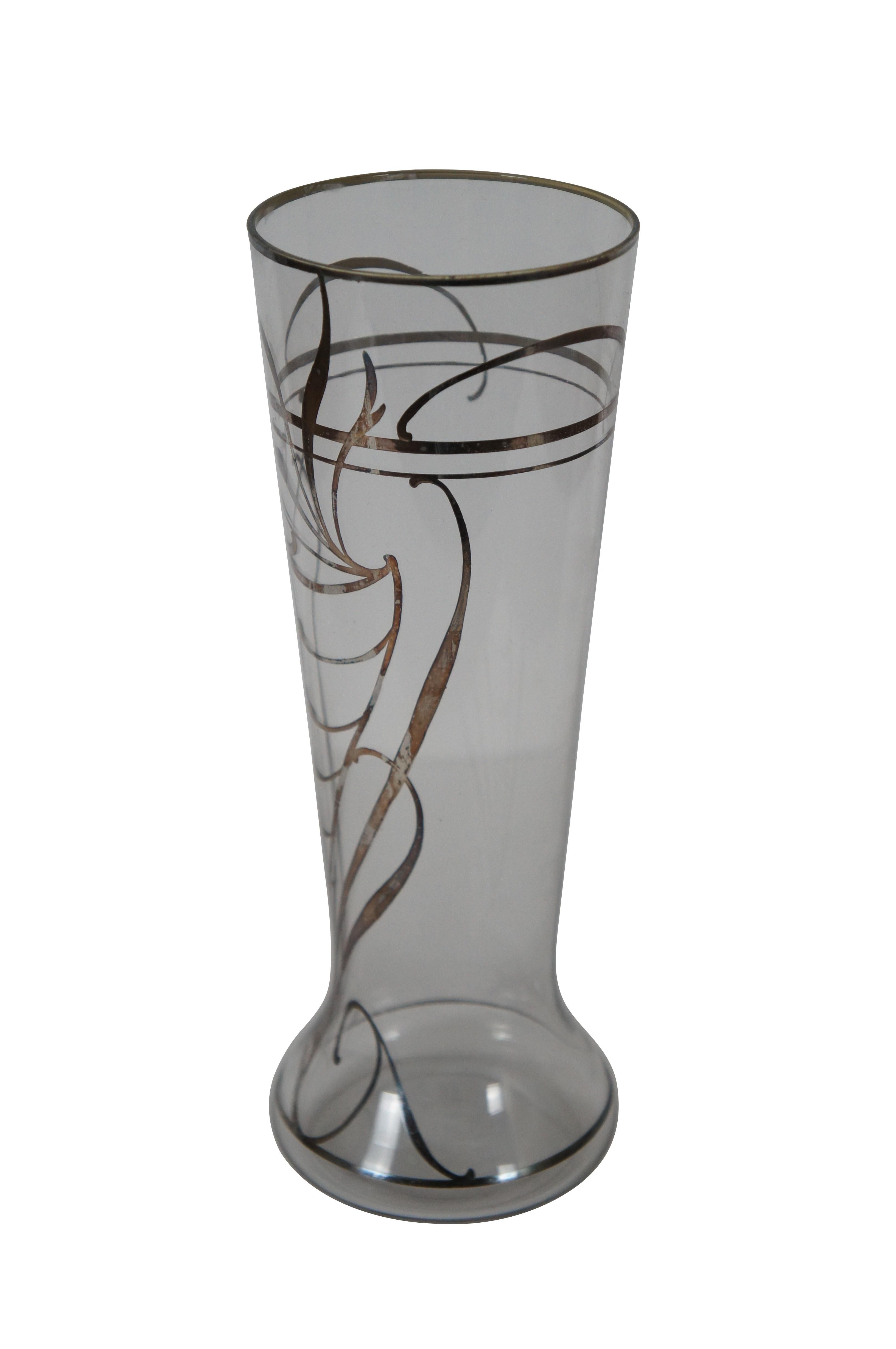 Antique clear glass vase with a slight trumpet / beer glass shape, overlaid with sterling silver in a semi-abstract Art Nouveau style cornucopia and swirling accents. 

Dimensions:
3.5” x 9.25” (Diameter x Height)