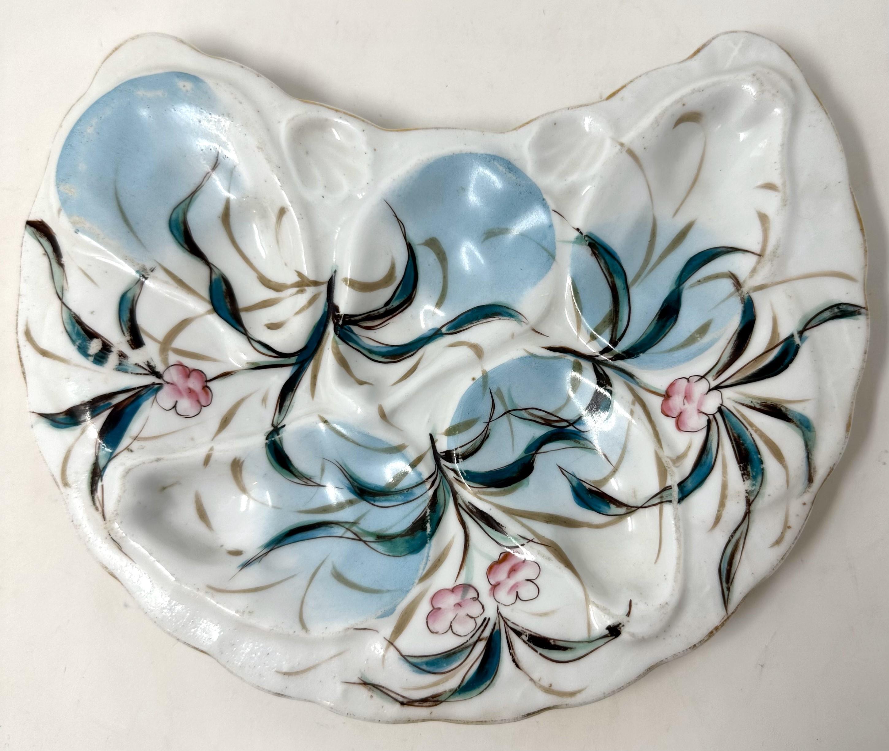 Antique Art Nouveau Continental Porcelain Crescent Shaped Oyster Plate, Circa 1910.
Hand-Painted Sea Grasses and Flowers in Blue Turquoise and Pink on a White Background.