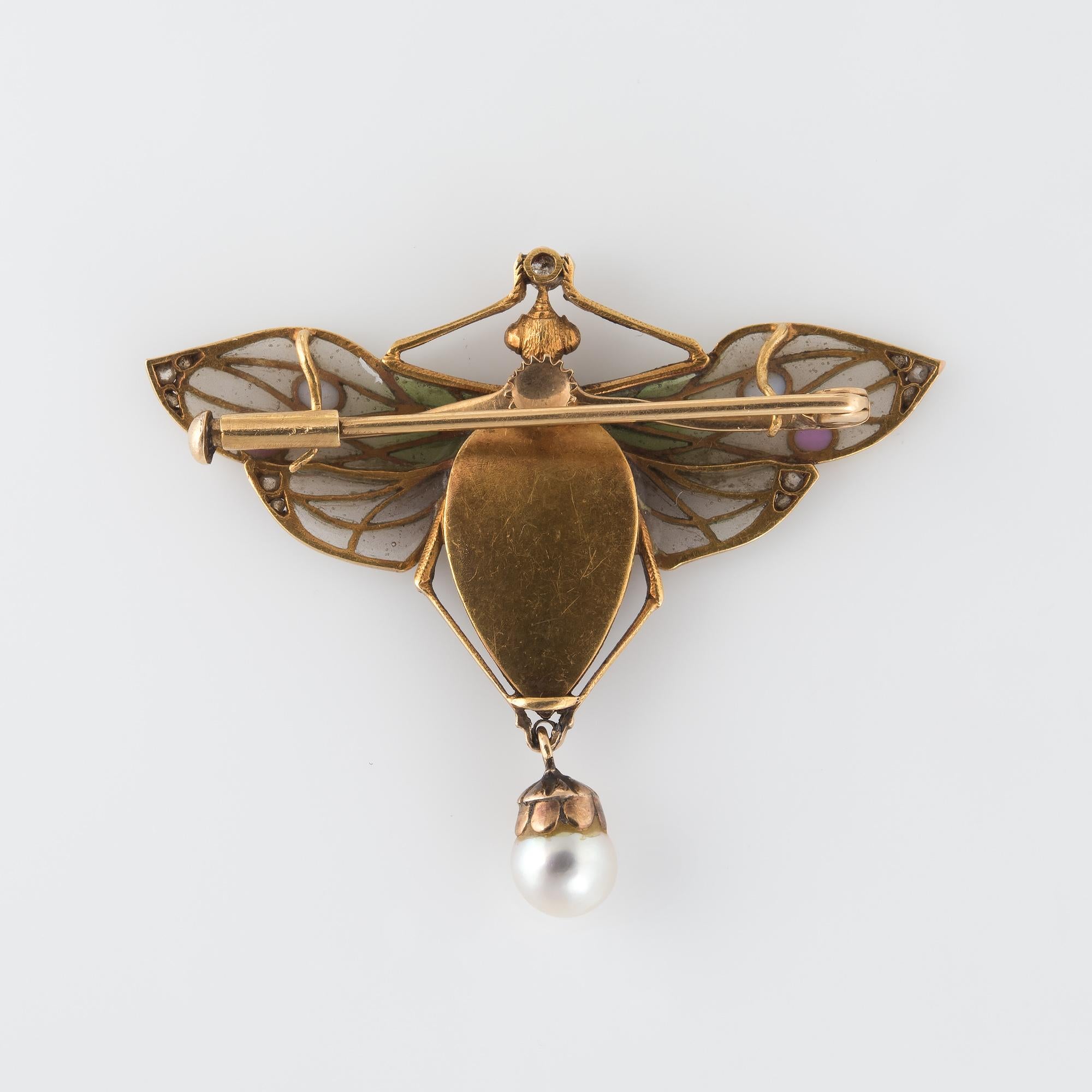 Captivating antique Art Nouveau plique-a-jour dragonfly brooch/pendant crafted in 18 karat yellow gold (circa 1900 to 1910s).  

Old mine and rose cut diamonds range in size from 0.01 to 0.05 carats. The total diamond weight is estimated at 0.19