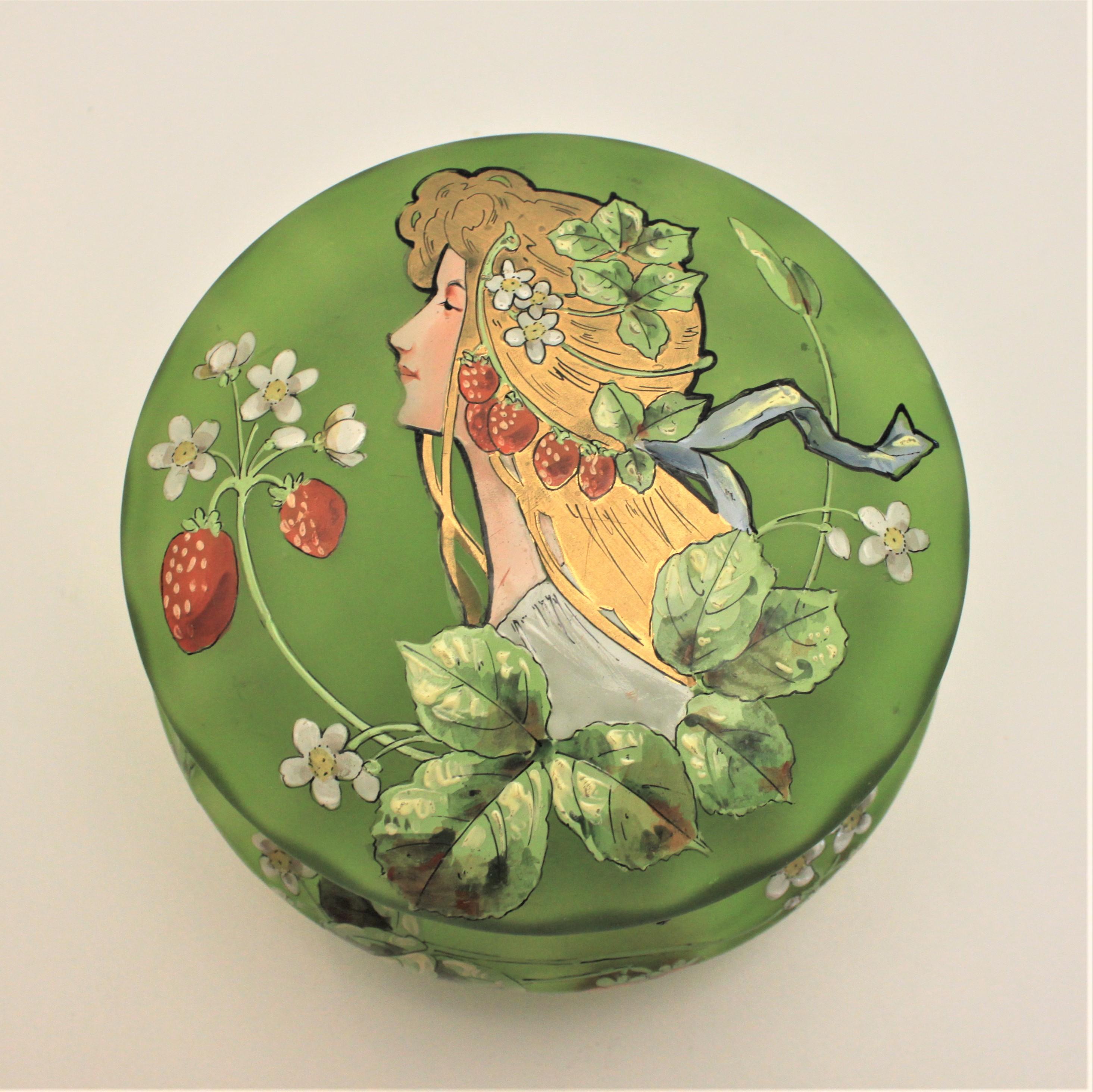 Cette jarre Art Nouveau en verre satiné vert émaillé provient très probablement d'Angleterre, mais n'est pas signée. Le plateau en verre satiné vert présente un portrait de femme peint à la main dans le style Art nouveau, avec des fraises sur une