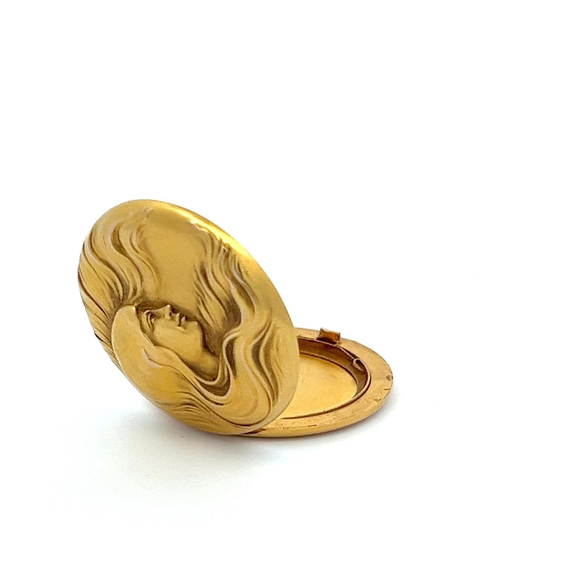 This 14 karat yellow gold medallion is a genuine artifact from the Art Nouveau period. It prominently features a woman, her gaze directed to the side and her long hair in fluid motion.

The locket captures the typical motifs of Art Nouveau,