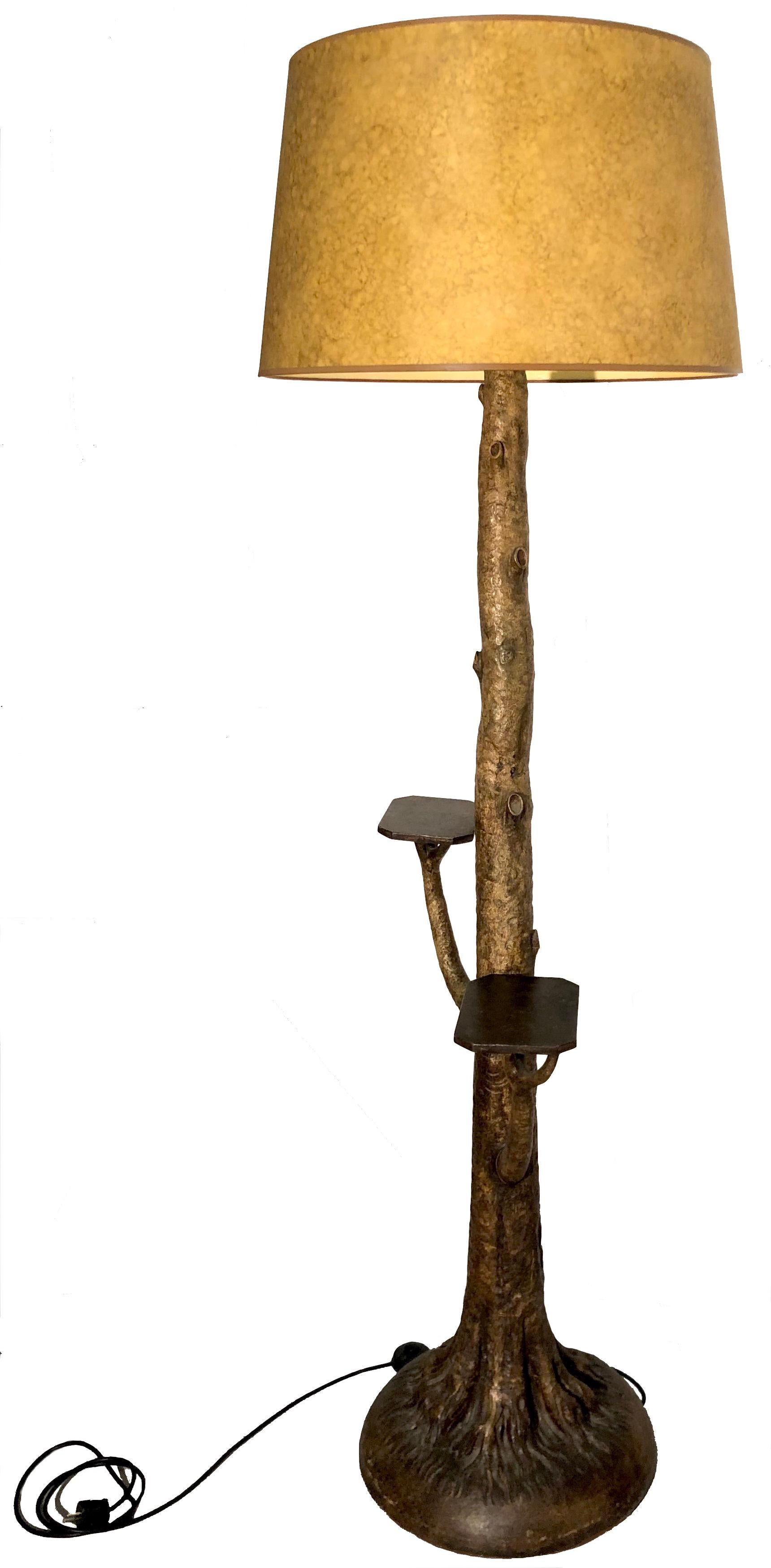 This very rare carved and painted wooden floor lamp is designed as a tree with it's roots. The latter form a round base. This most unusual object has preserved it's original painting with it's beautiful patina. Two octagonal wooden shelves are