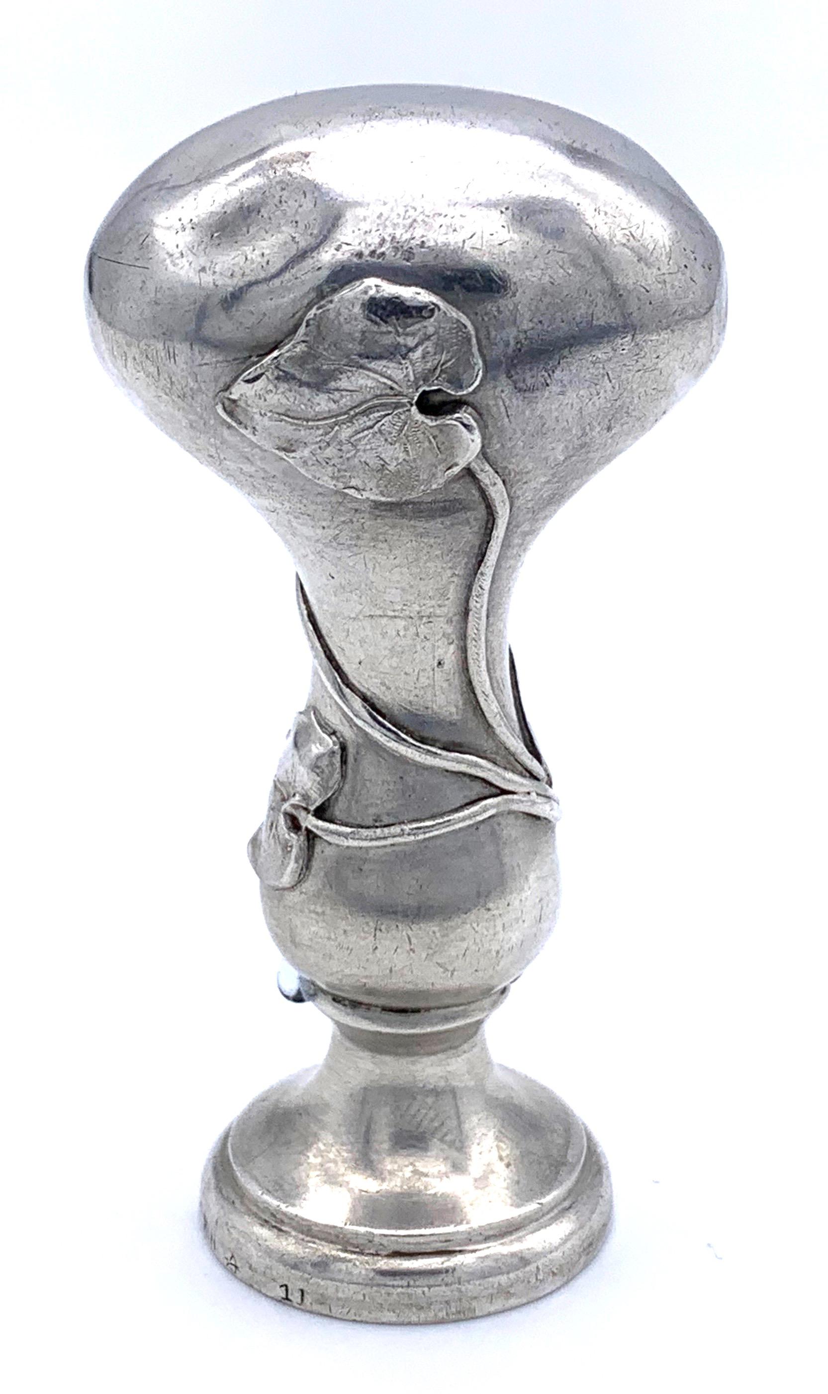 This Art Nouveau desktop seal is engraved with the  ligated initials A and B. Around the handle is a typical Art Nouveau entwined flower and leaf motive. The seal dates back to 1895-1900 and is impressed with German hallmarks for silver. 