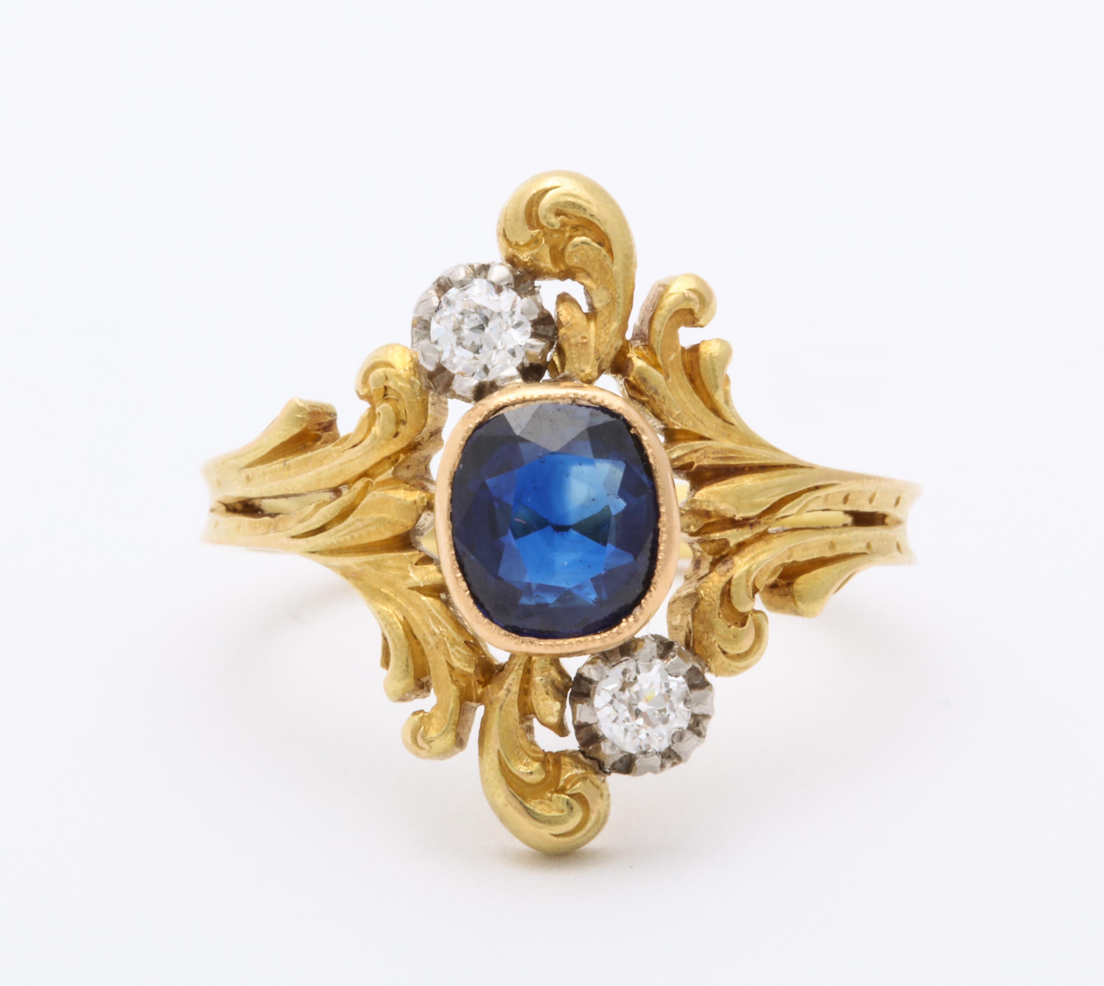 All elegance and fineness, the curves if the Art Nouveau period sparkle on this 18 kt gold ring with two european cut diamonds counterposed against a natural ceylon sapphire, like the stars in the starry night. The shank is a continuation of these