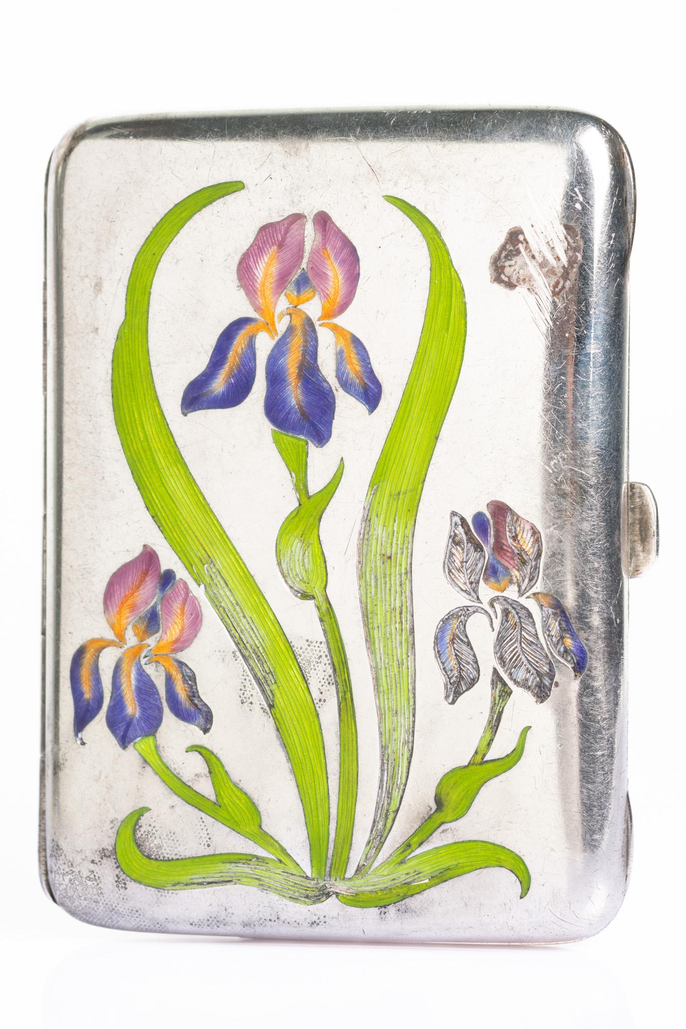 Antique Art Nouveau German silver cigarette case featuring a hand-painted enamel design of blooming irises — a classic motif symbolising hope, wisdom, and faith. The sinuous lines of the green stems and the soft shades of violet, blue and oranger