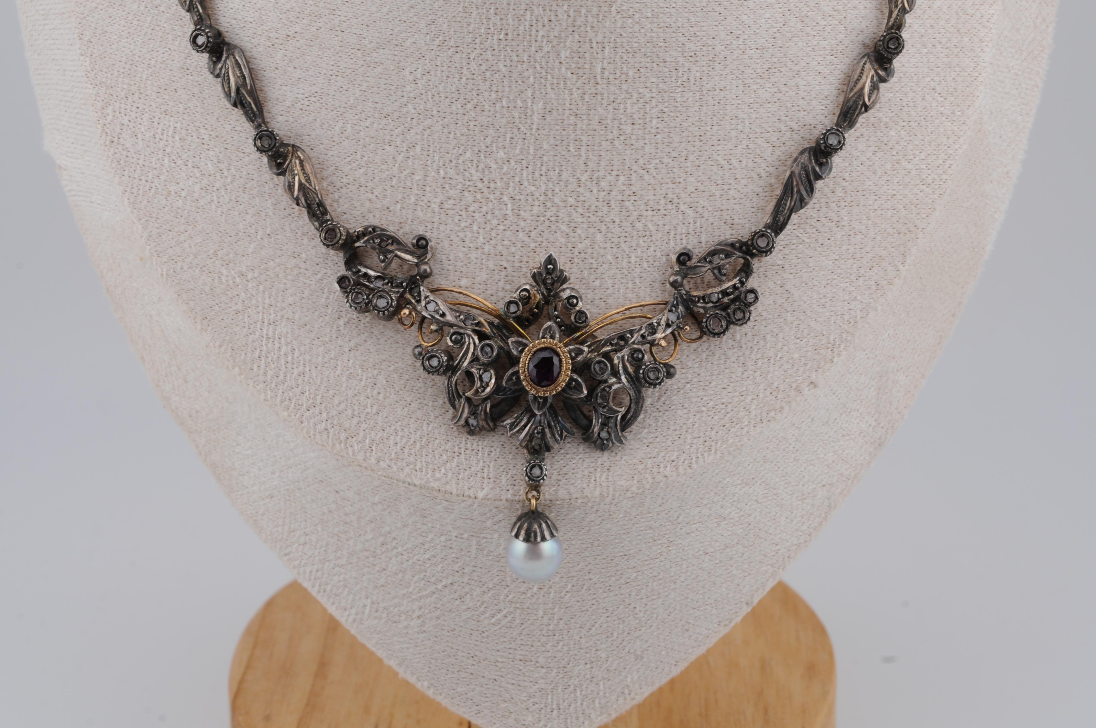 Dieses atemberaubende Collier aus 18 Karat Gelbgold aus der Zeit des Jugendstils besticht durch zarte Silberelemente und außergewöhnliche Filigranarbeit. Er ist mit kleinen Diamanten, einem prächtigen Rubin von 1 Karat und einer Tahiti-Perle