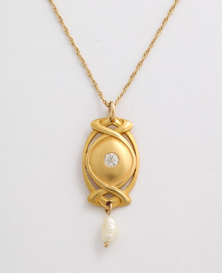 A beautifully bloomed, delicate 14 Kt gold Art Nouveau pendant suspends a blister pearl and has, at center, a bright, white diamond old diamond of approximately .13 cts. Blister pearls were often a choice during the Art Nouveau period. Concentration