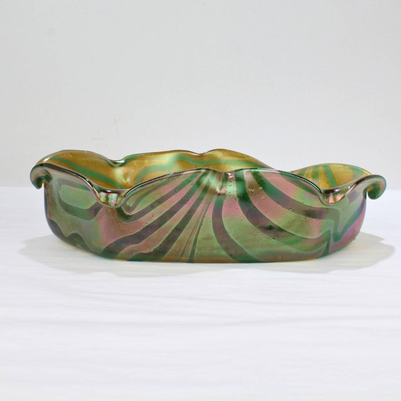 A good Kralik Glassworks Loetz type art glass bowl.

With pulled aqua on gold iridescent finish. 

Kralik Glassworks was among the leaders in European glass making along with Loetz, Moser, Meyr's Neffe, and Lobmeyr at the beginning of the 20th