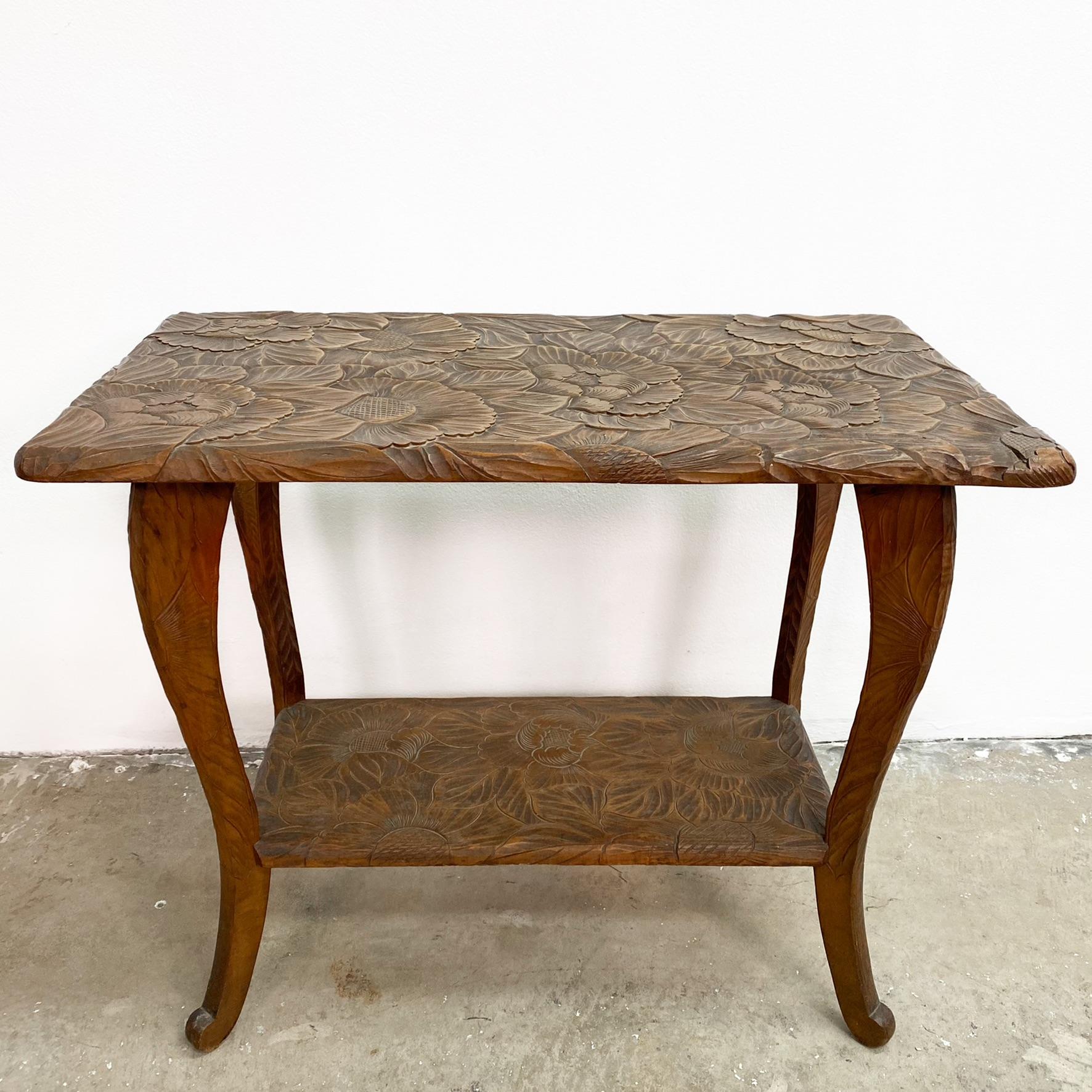 Stunning antique Art Nouveau side table, circa 1900, retailed by Liberty and Co,of London. These tables were hand carved in Japan to feature exotic and botanical motifs.

Featuring a deeply hand carved sunflower design, which is graphically bold