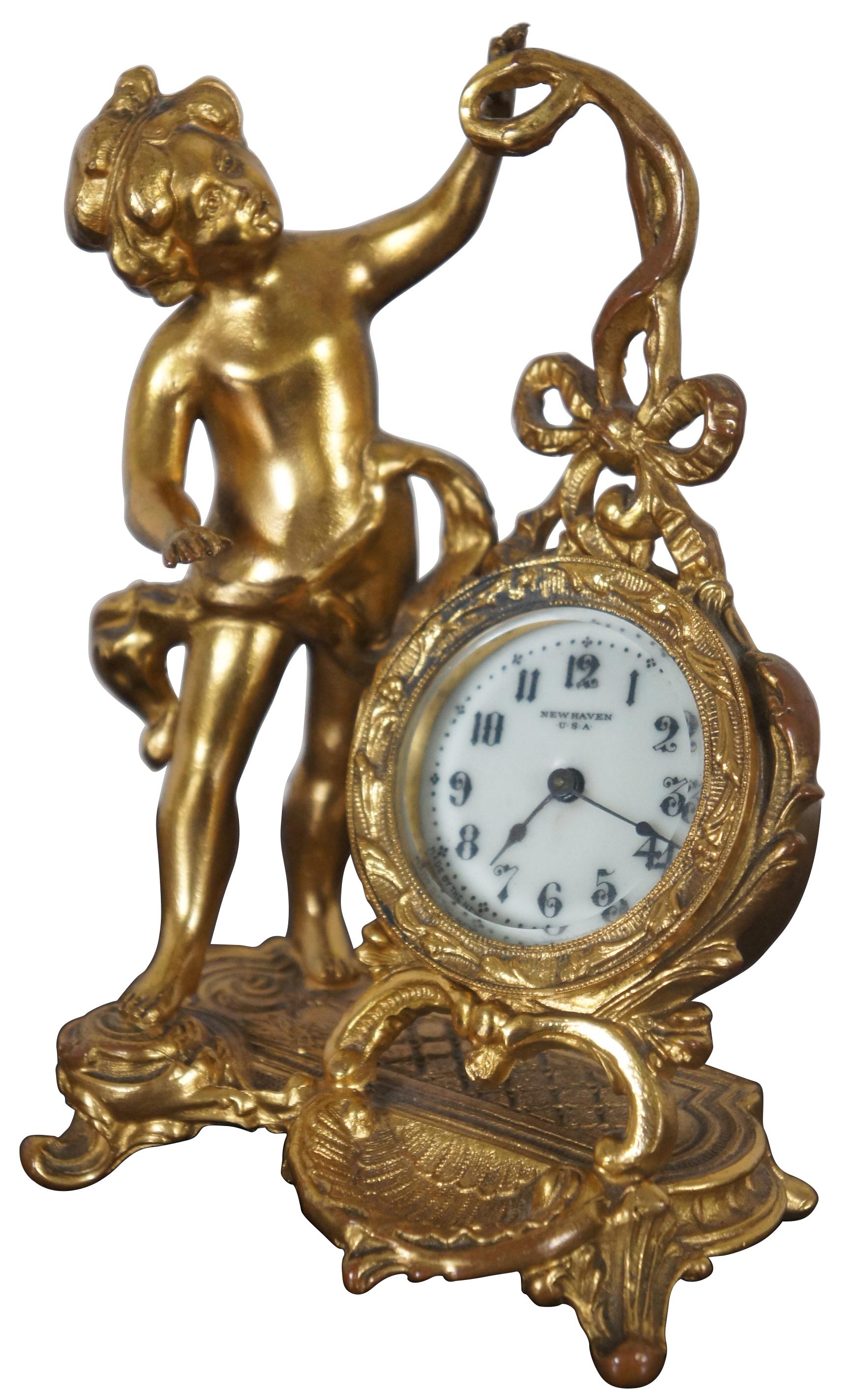 Antique Art Nouveau gilt metal cherub tabletop clock by the New Haven Clock Company.
  