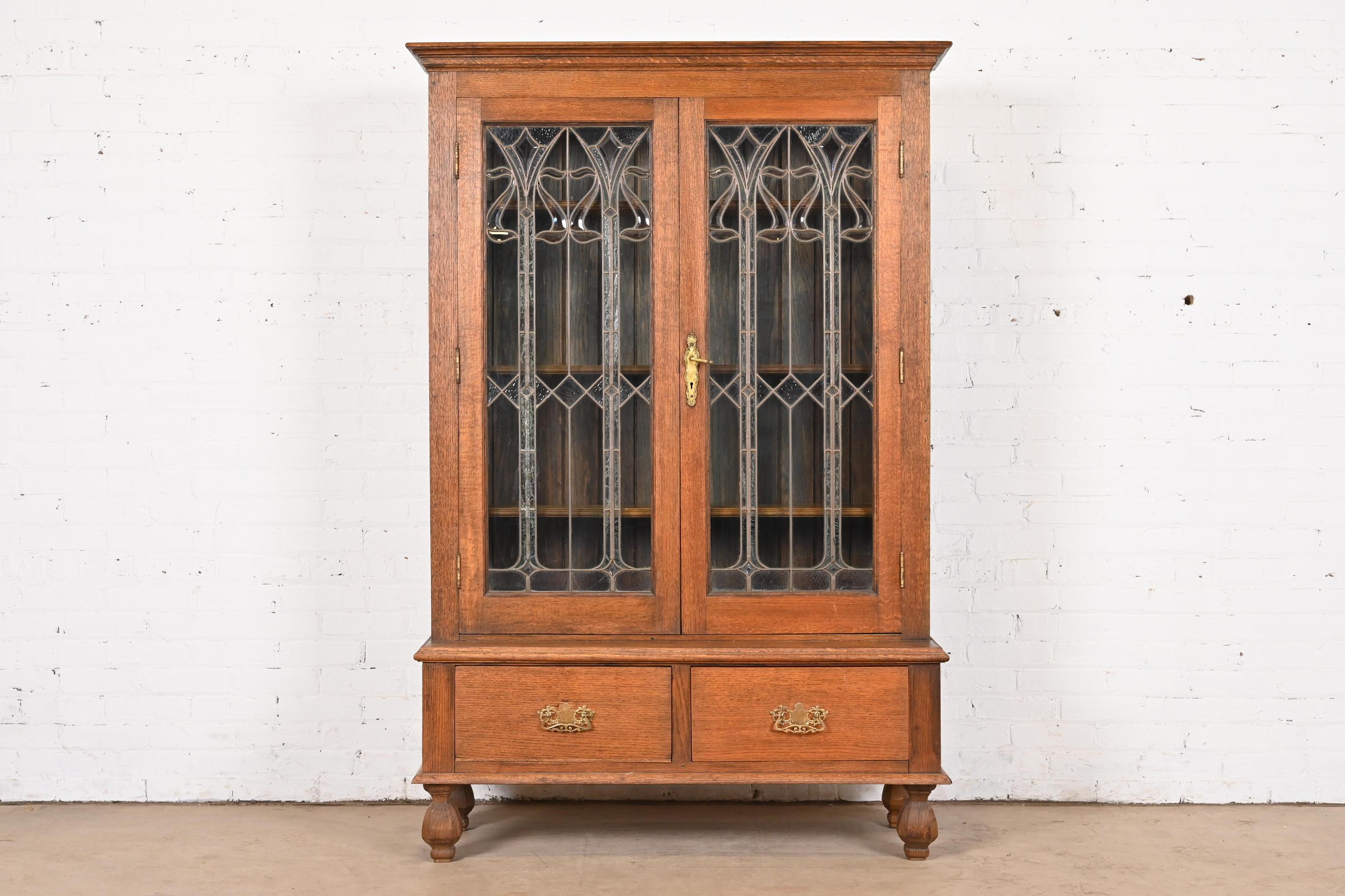 A gorgeous antique Art Nouveau or Arts & Crafts bookcase cabinet

USA, Circa 1900

Carved quarter sawn oak, with beautiful beveled leaded glass doors and brass hardware.

Measures: 45