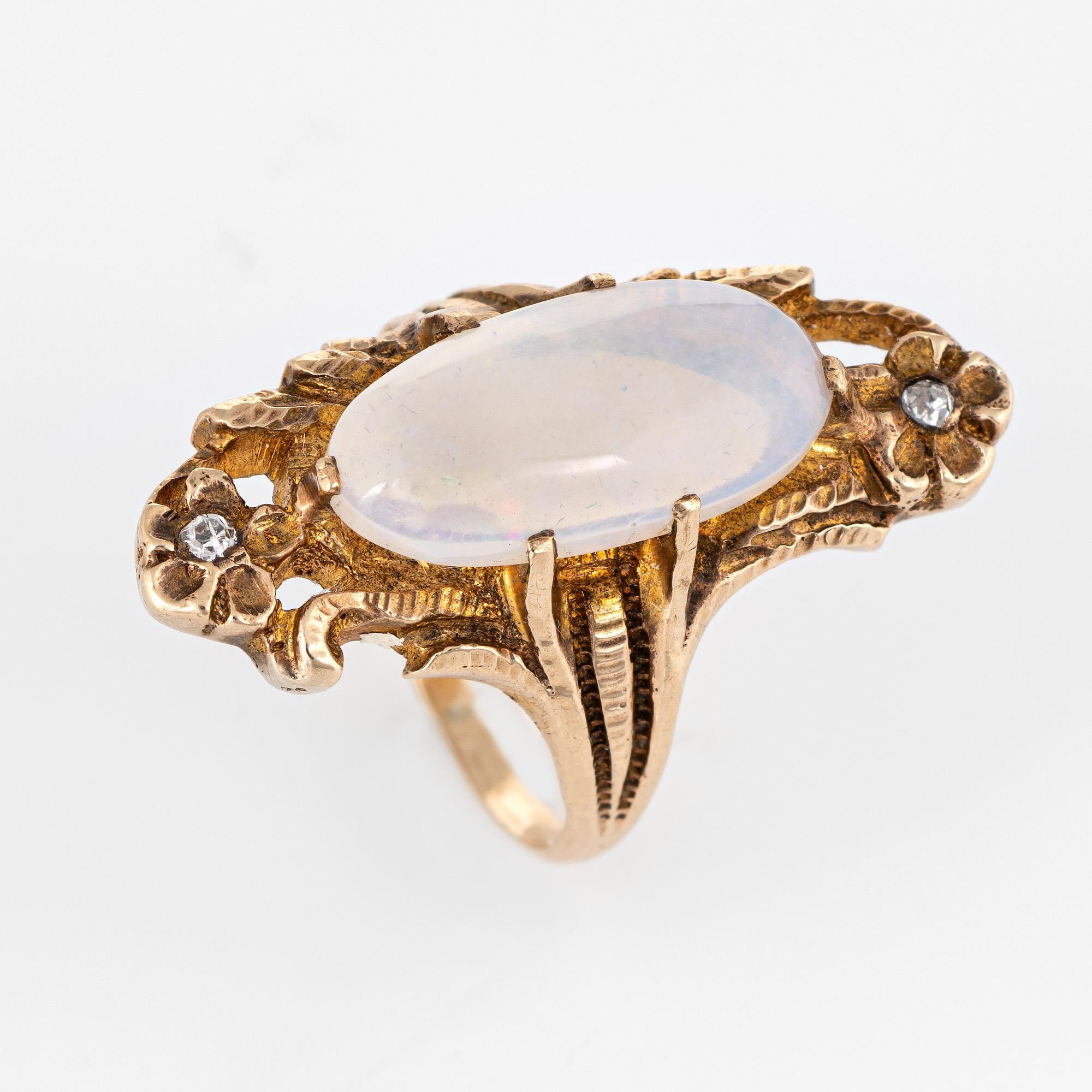 Finely detailed antique Art Nouveau era opal & diamond ring (circa 1900s to 1910s) crafted in 10 karat yellow gold. 

Cabochon cut opal measures 16mm x 7.5mm (estimated at 3.50 carats), accented with two estimated 0.01 carat old single cut diamonds.