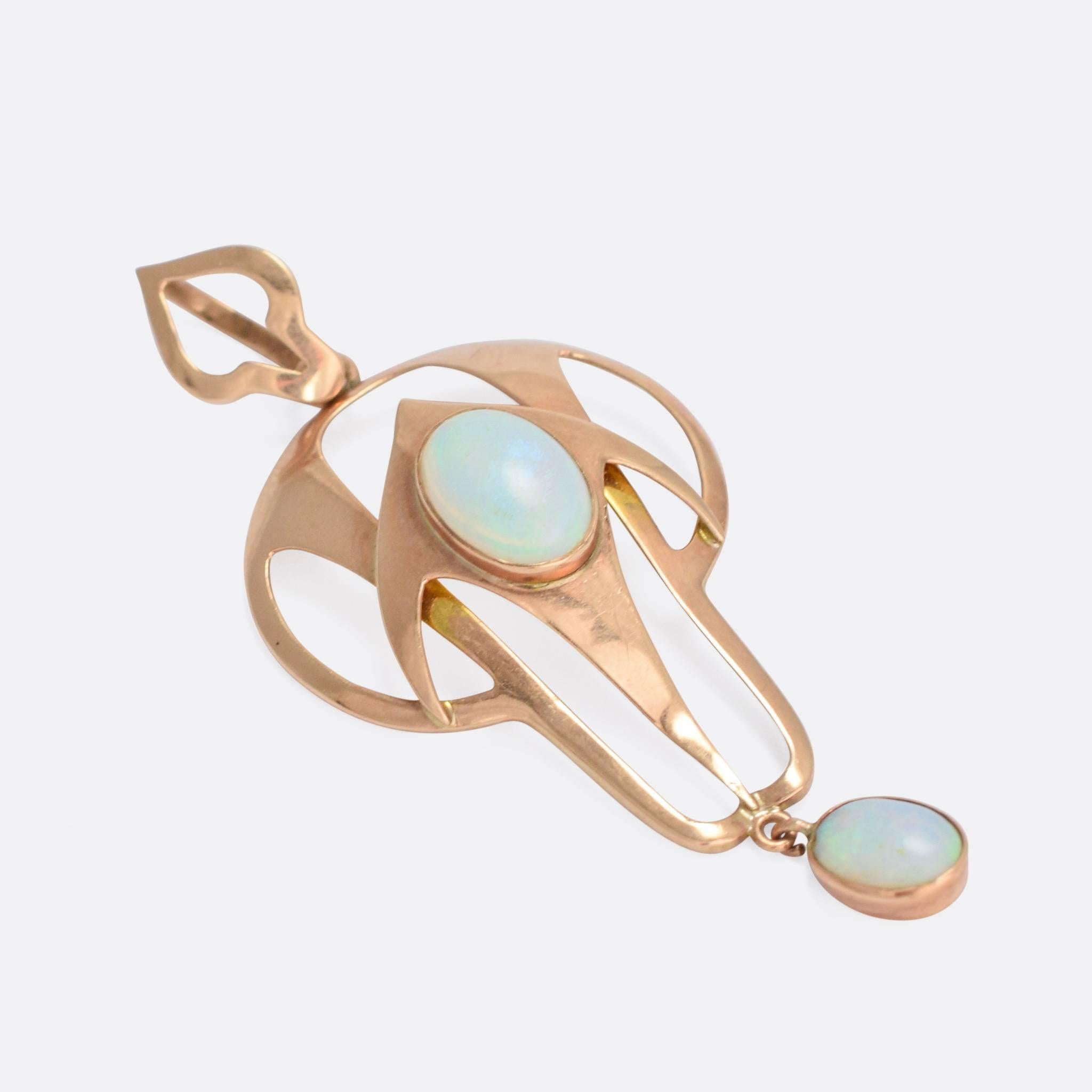 A stylish antique pendant crafted in the Art Nouveau style. Set with two vibrant, colourful opals, the piece is modelled in 9k rose gold - complete with the original articulated bail. The graceful curves and lines are very typical of the style, and