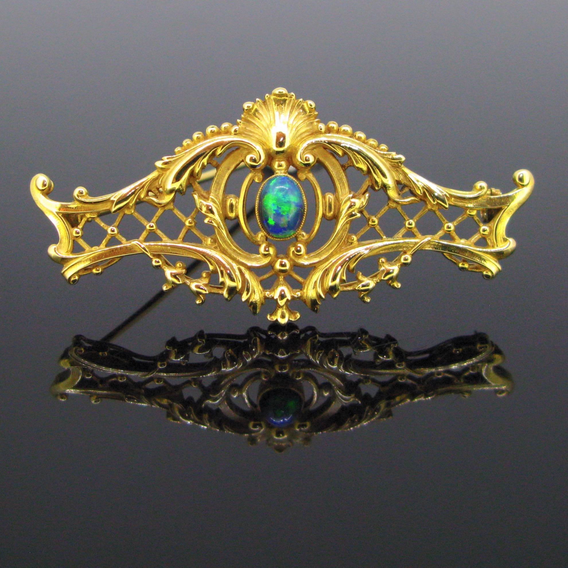 This beautiful brooch is from the Art Nouveau era. It was made circa 1900. It is fullt made in 18kt yellow gold, set with a vibrant black opal in the centre. It has a very nice design with flowers and volutes. It is controlled with the French mark