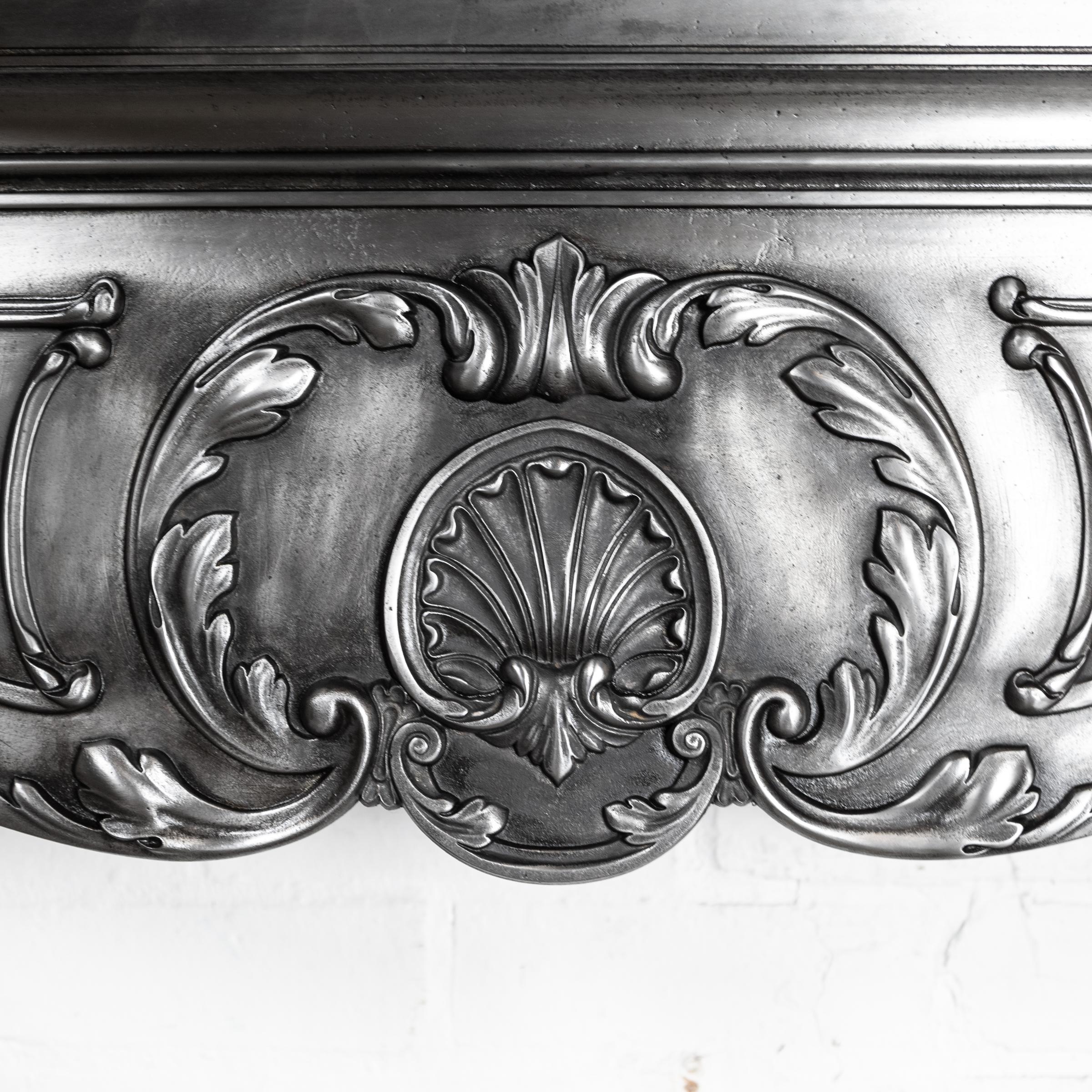Cheminée originale en fonte du XIXe siècle, polie à la main pour une finition spectaculaire. Cette rare cheminée ancienne en fonte est ornée de détails.

La tablette et l'ouverture en serpentin de la façade, ainsi que les feuilles d'acanthe à