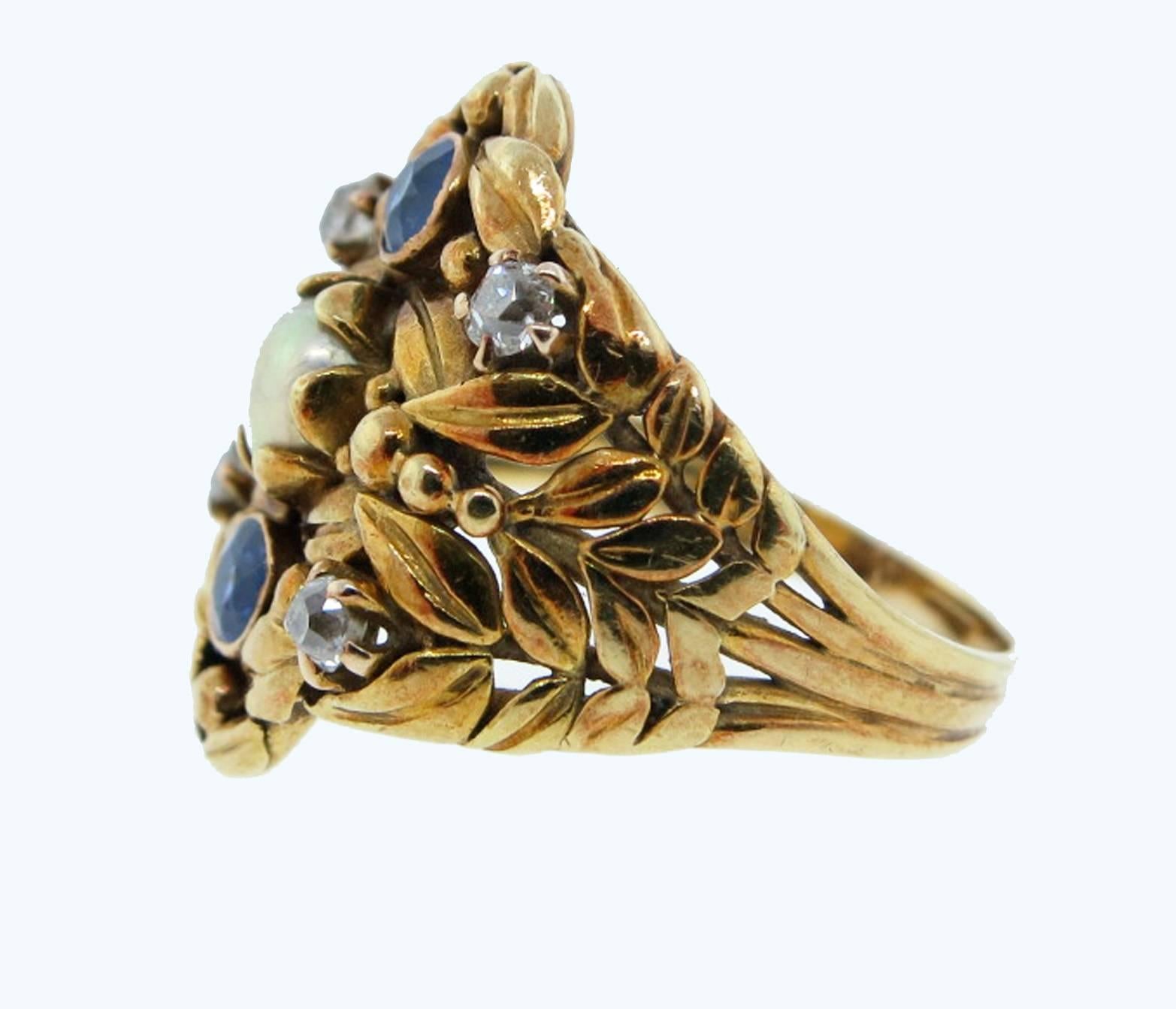 Lovely 14kt. yellow gold Art Nouveau ring circa 1910. The leaf design motif is set with a center natural pearl measuring approx 4.0mm. two natural cornflower blue sapphires and four old European cut diamonds. Size 6 and can be sized. 