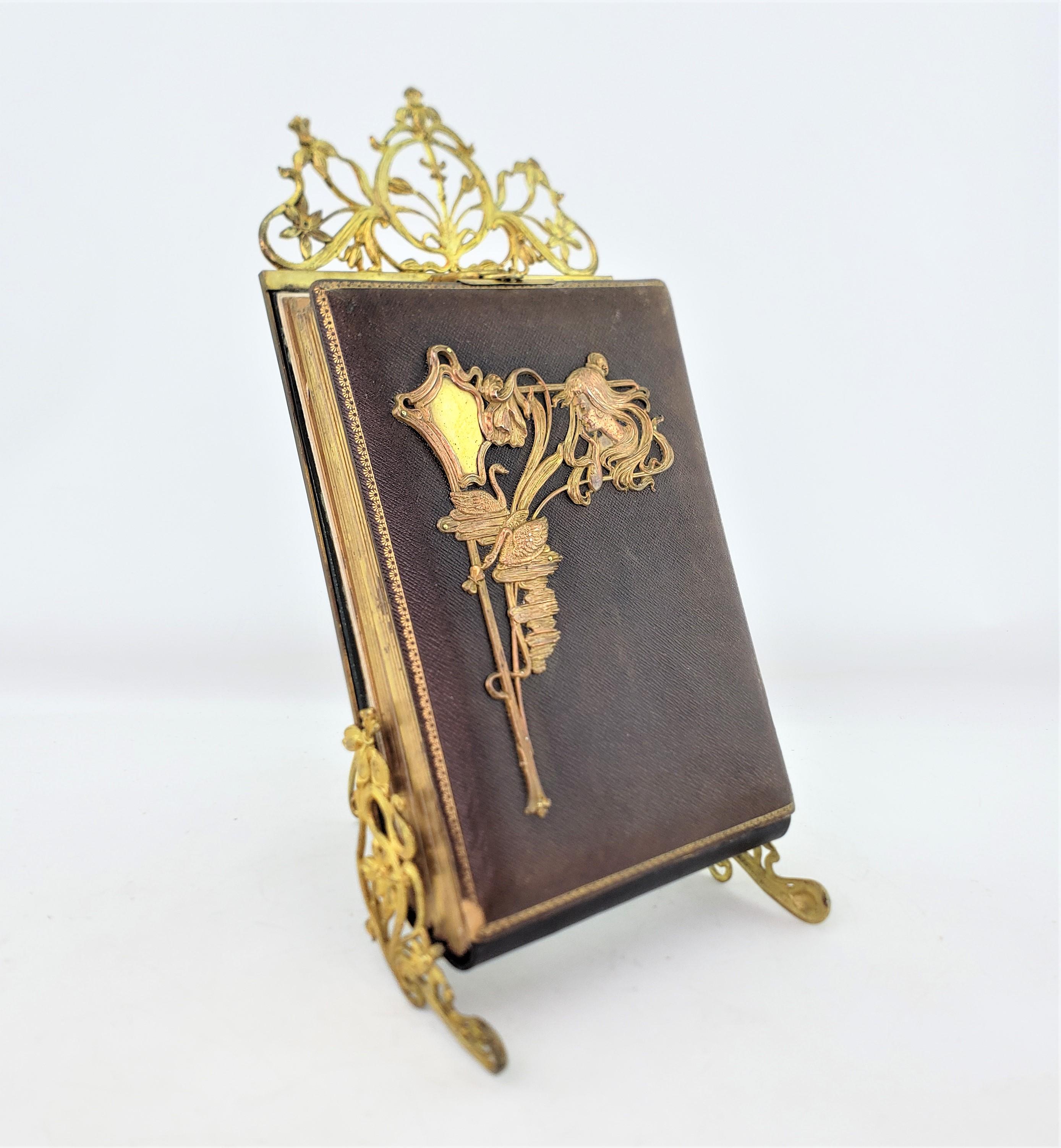 This antique standing photo album is unsigned, but presumed to have originated from France and date to approximately 1900 and done in the period Art Nouveau style. The album is composed of thick cardboard stock with printed floral decoration around