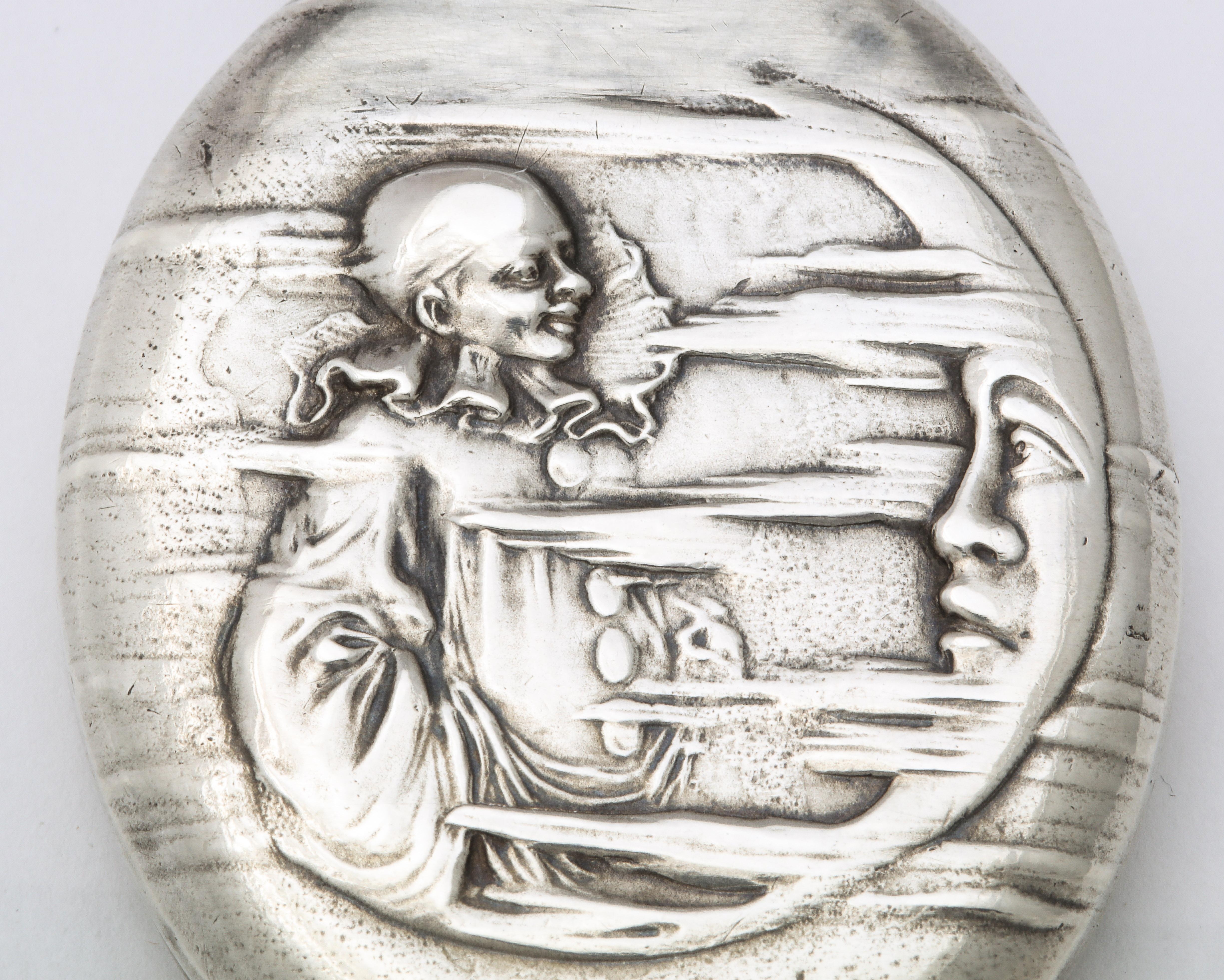 A delightful Art Nouveau locket, with a unique theme, presents an image of Pierrot smiling with amusement as he is in conversation with the man in the crescent moon. Clouds move along the face and opposite side of the locket as the man in the moon