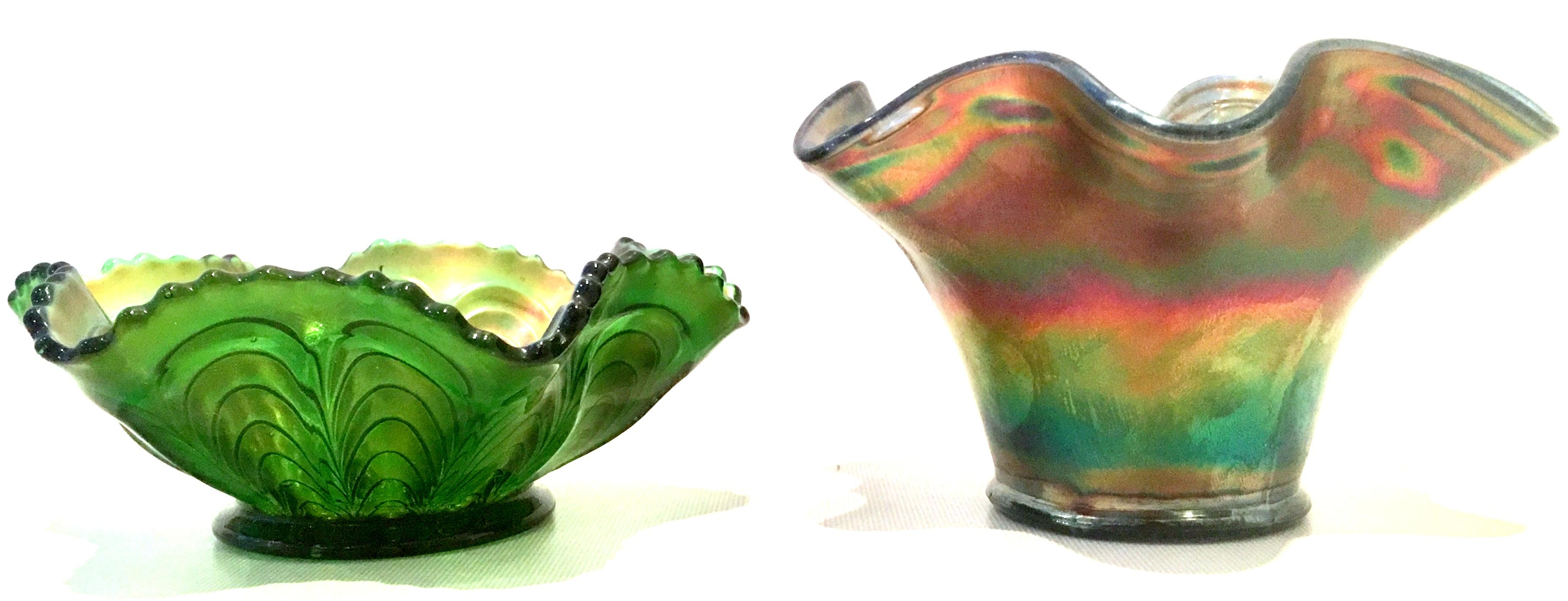 Antique set of two art Nouveau American art glass iridescent six point ruffle bowls. The shorter bowl is green iridescent and has a raised pulled feather motif. The taller is blue iridescent with a raised fauna and berry motif.
The green bowl