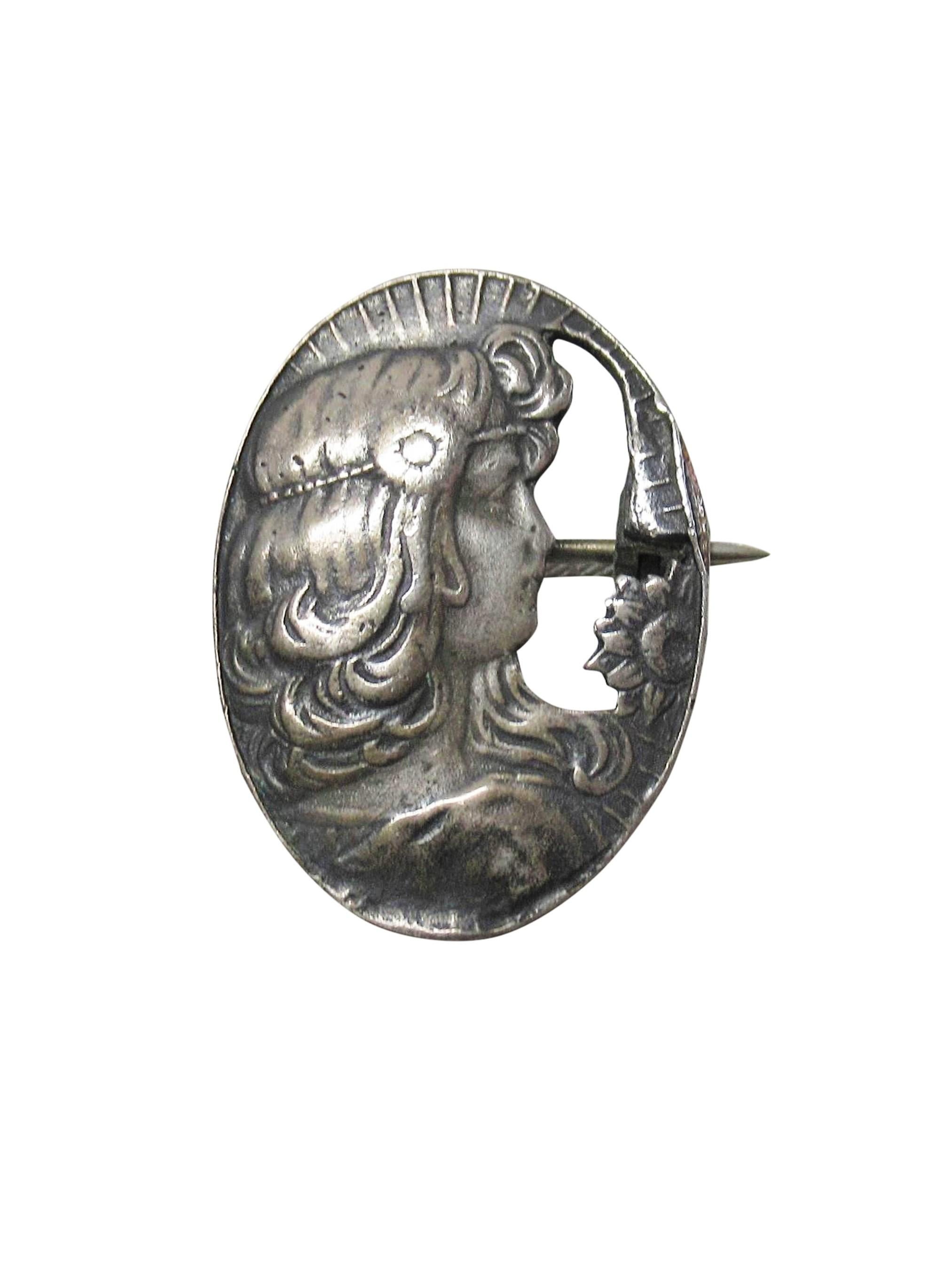 Lovely Art Nouveau sterling silver pendant and brooch featuring the profile of a woman. She is quite lovely, with flowing hair adorned with headband hair jewelry further embellished with a flower. She has sunrays atop her head and a sunflower across
