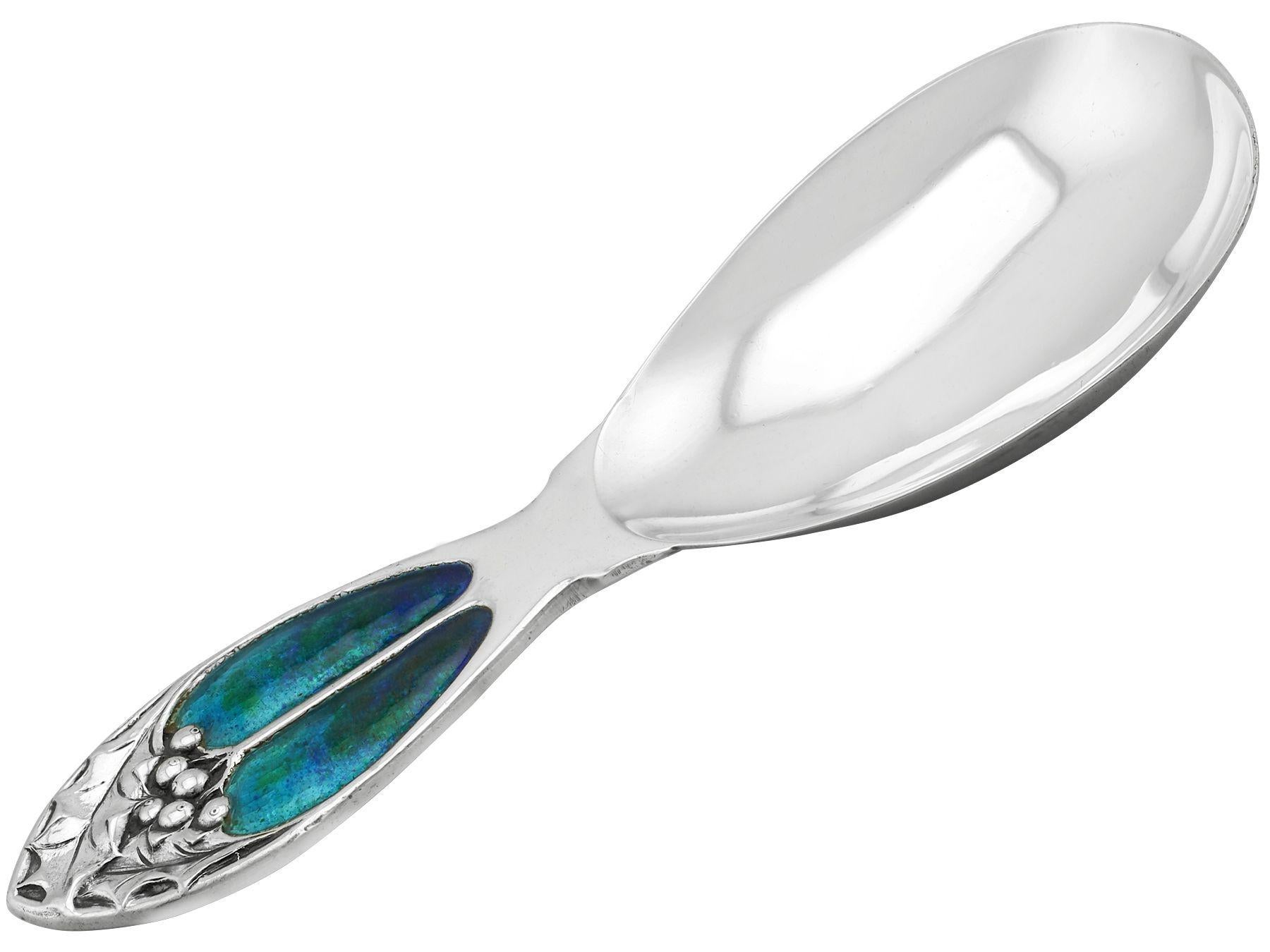 An exceptional, fine and impressive antique George V English sterling silver and enamel caddy spoon in the Art Nouveau style; an addition to our silver teaware collection.

This exceptional antique George V sterling silver caddy spoon has a plain