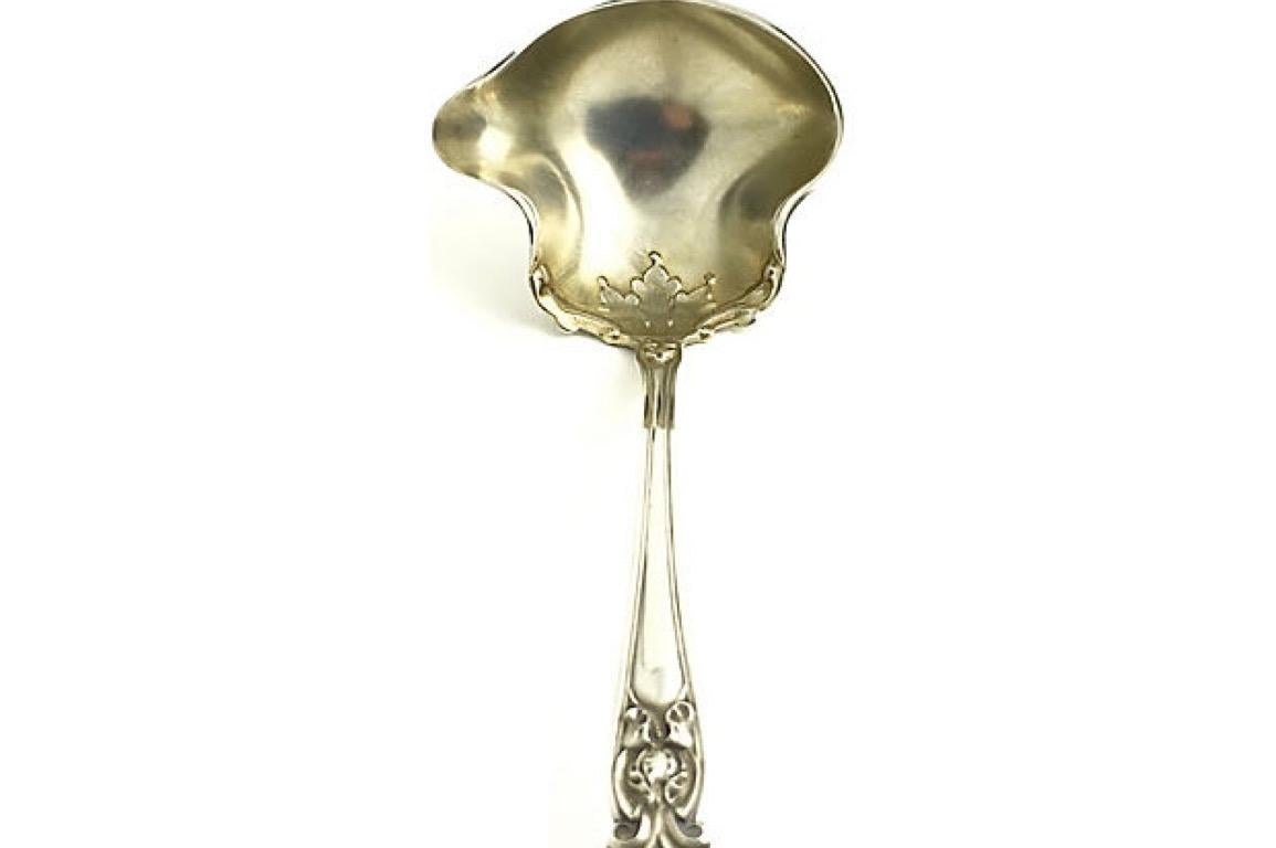 Art Nouveau sterling silver ladle useful for cream, sauce or gravy. This label features a floral design on the handle as well as in the interior of the spoon area. The piece is marked sterling with the hallmark for Manchester Sterling. It has a