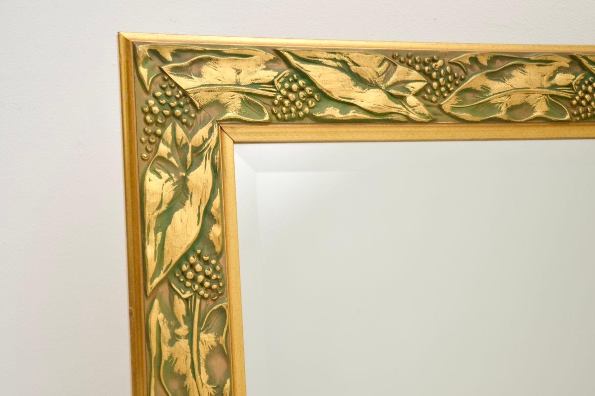 Magnifique miroir ancien de style Arte Antiques, fabriqué en Angleterre et datant des années 1960 environ.

Le cadre est en bois massif magnifiquement sculpté avec des motifs de vigne, en finition or et vert. Le verre a des bords biseautés et est