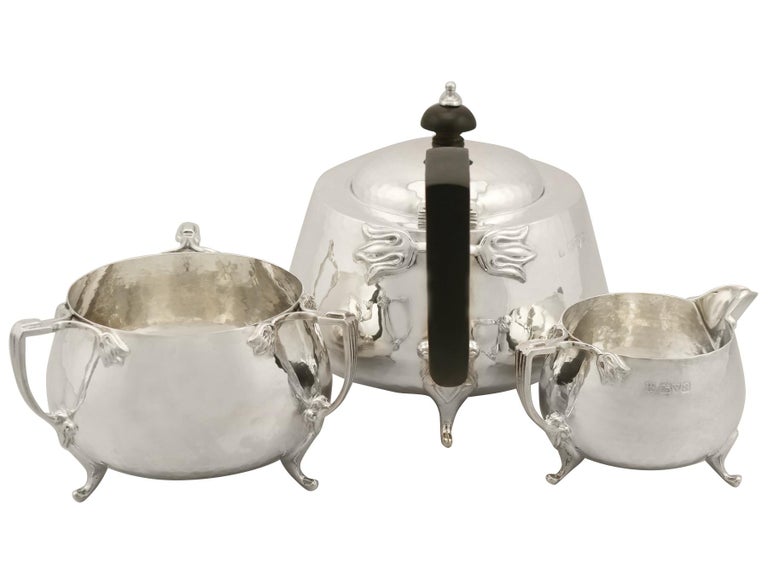 A fine and impressive antique George V English sterling silver three-piece tea service in the Art Nouveau style; an addition to our antique teaware collection.

This fine antique George V sterling silver three-piece tea set/service consists of a