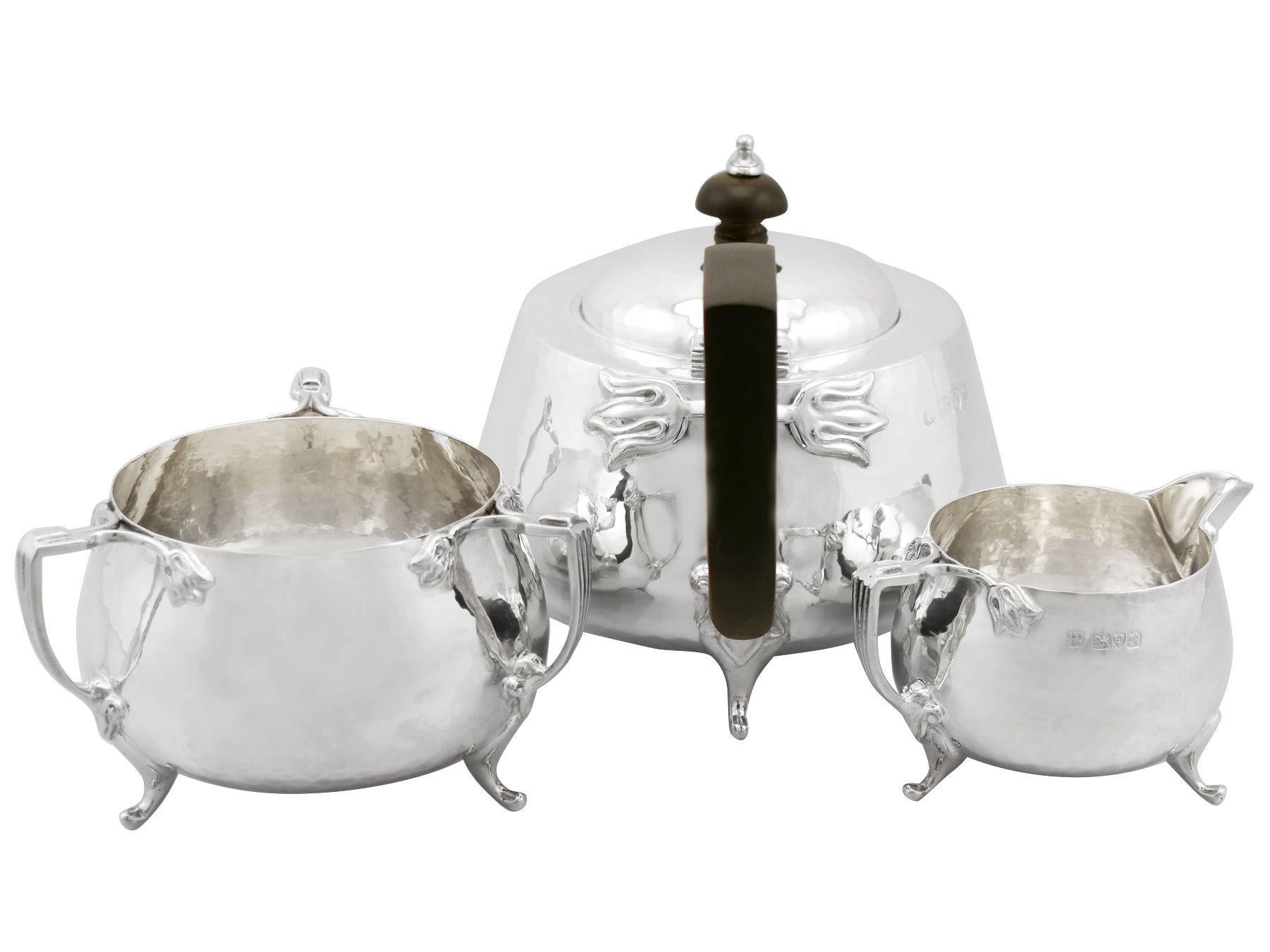 A fine and impressive antique George V English sterling silver three-piece tea service in the Art Nouveau style; an addition to our antique teaware collection.

This fine antique George V sterling silver three-piece tea set/service consists of a