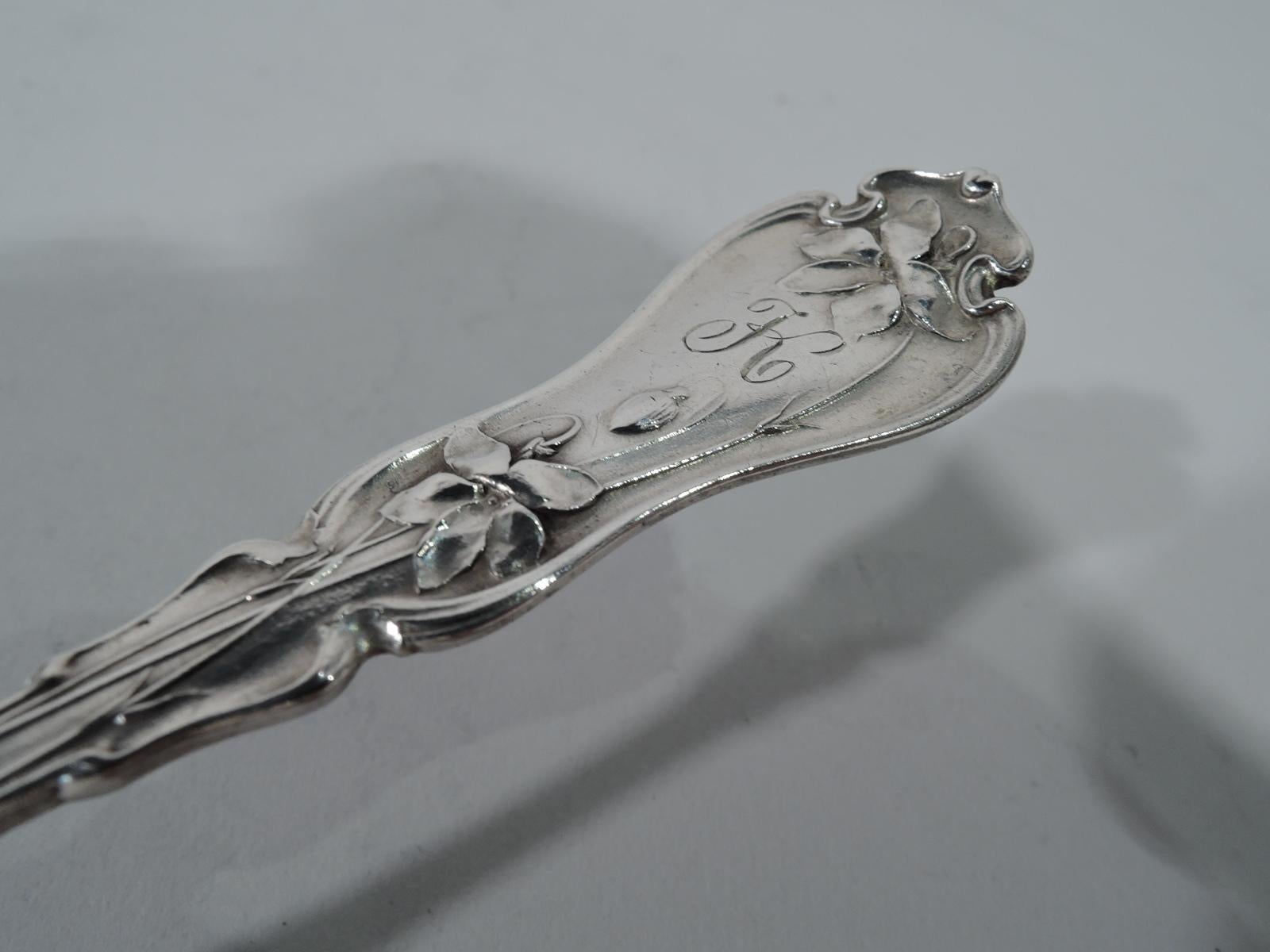 Antique sterling silver serving piece. Made by Whiting in New York. Shaped terminal with raised flowers and engraved single letter script monogram (K). Shaped and serrated blade with more flowers and pierced elongated scrolls. A pretty piece in an