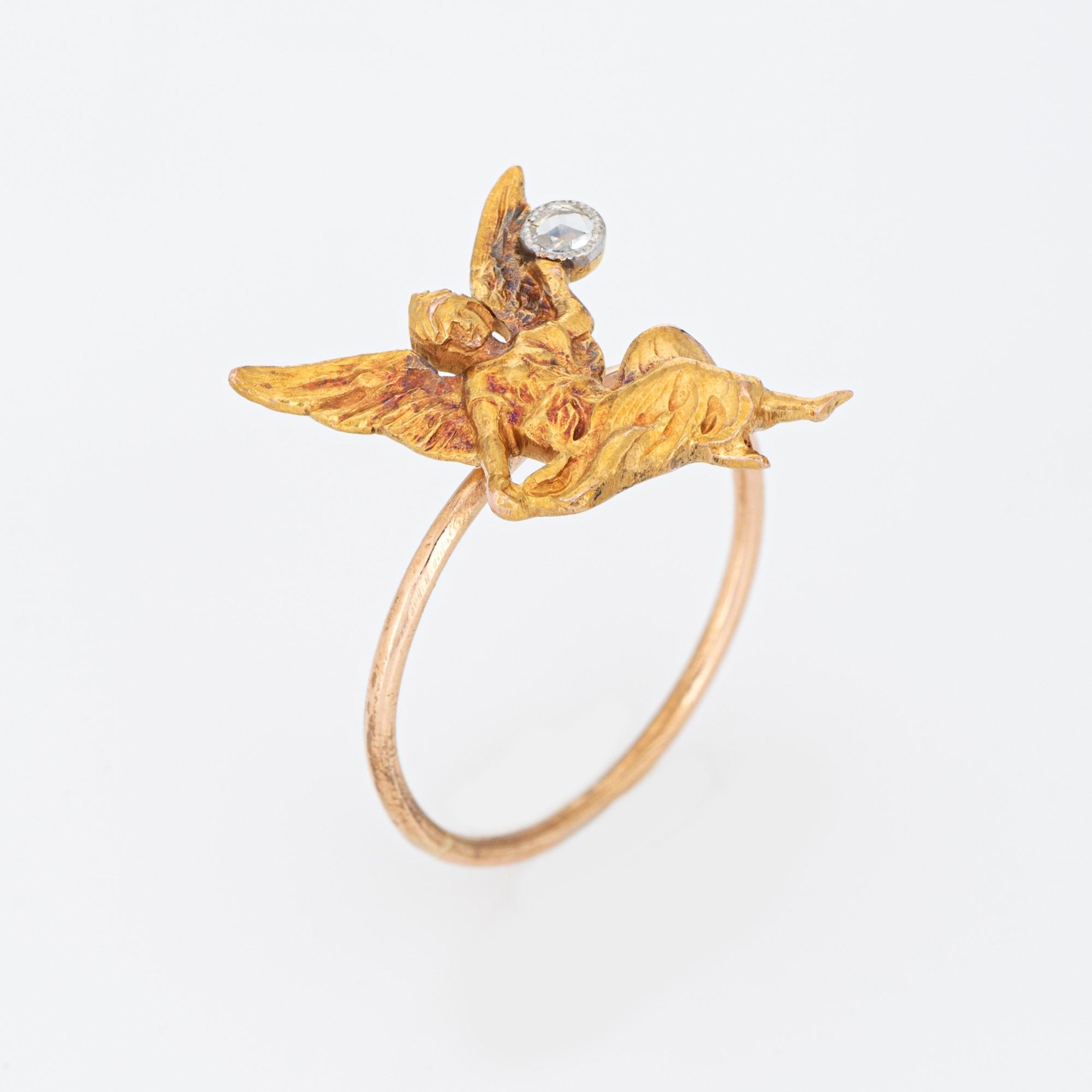 Originally an antique Art Nouveau era stick pin (circa 1900s to 1910s), the winged angel is crafted in 18 karat yellow gold.

The ring is mounted with the original stick pin. Our jeweler rounded the stick pin into a slim band for the finger. The