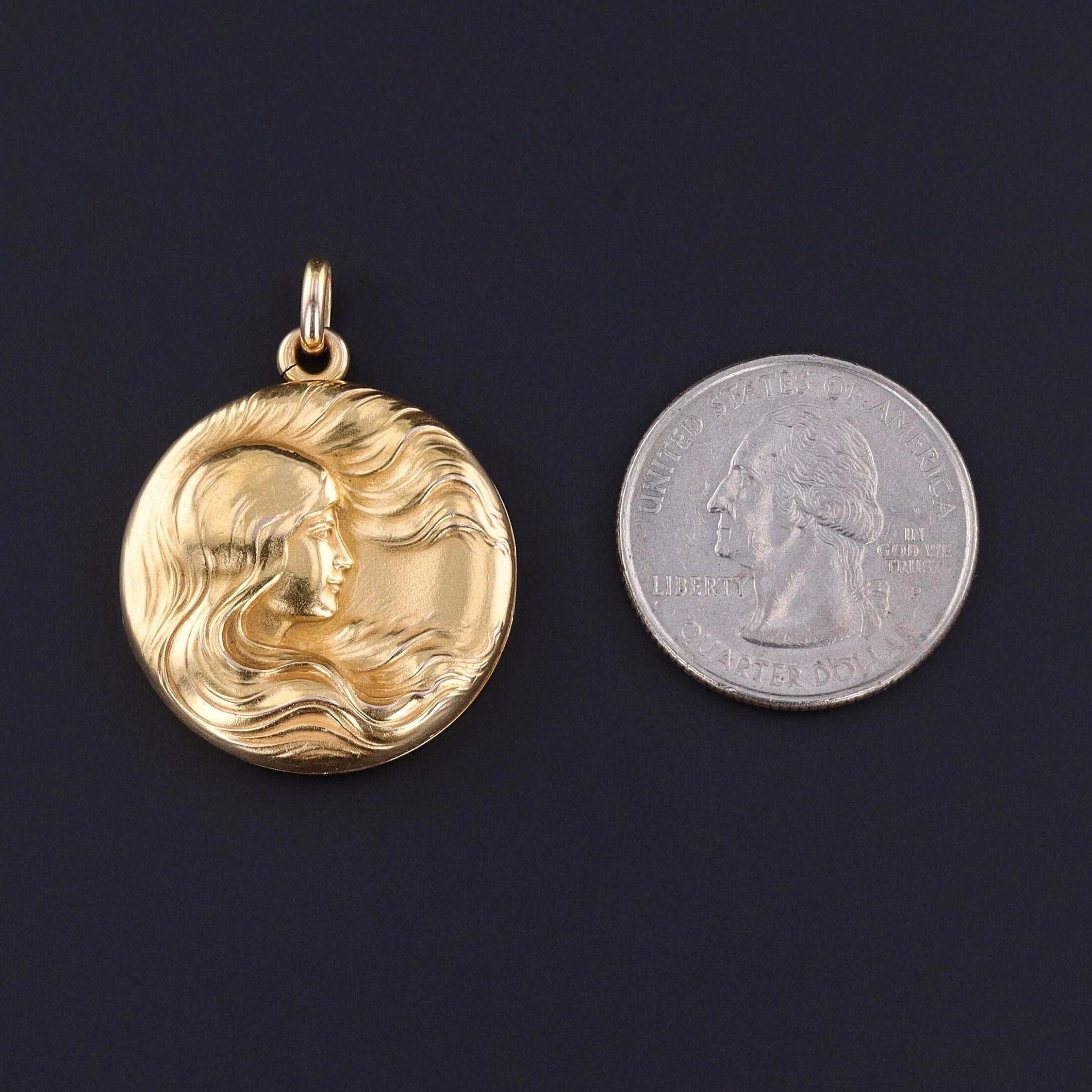 Medaglione donna Art Nouveau: Un'elegante donna in oro 14k con capelli al vento adorna questo medaglione antico e brillante.

Il pezzo misura 1,4 pollici dalla parte superiore della cauzione a quella inferiore, è largo 1 pollice e pesa 7,26 grammi.