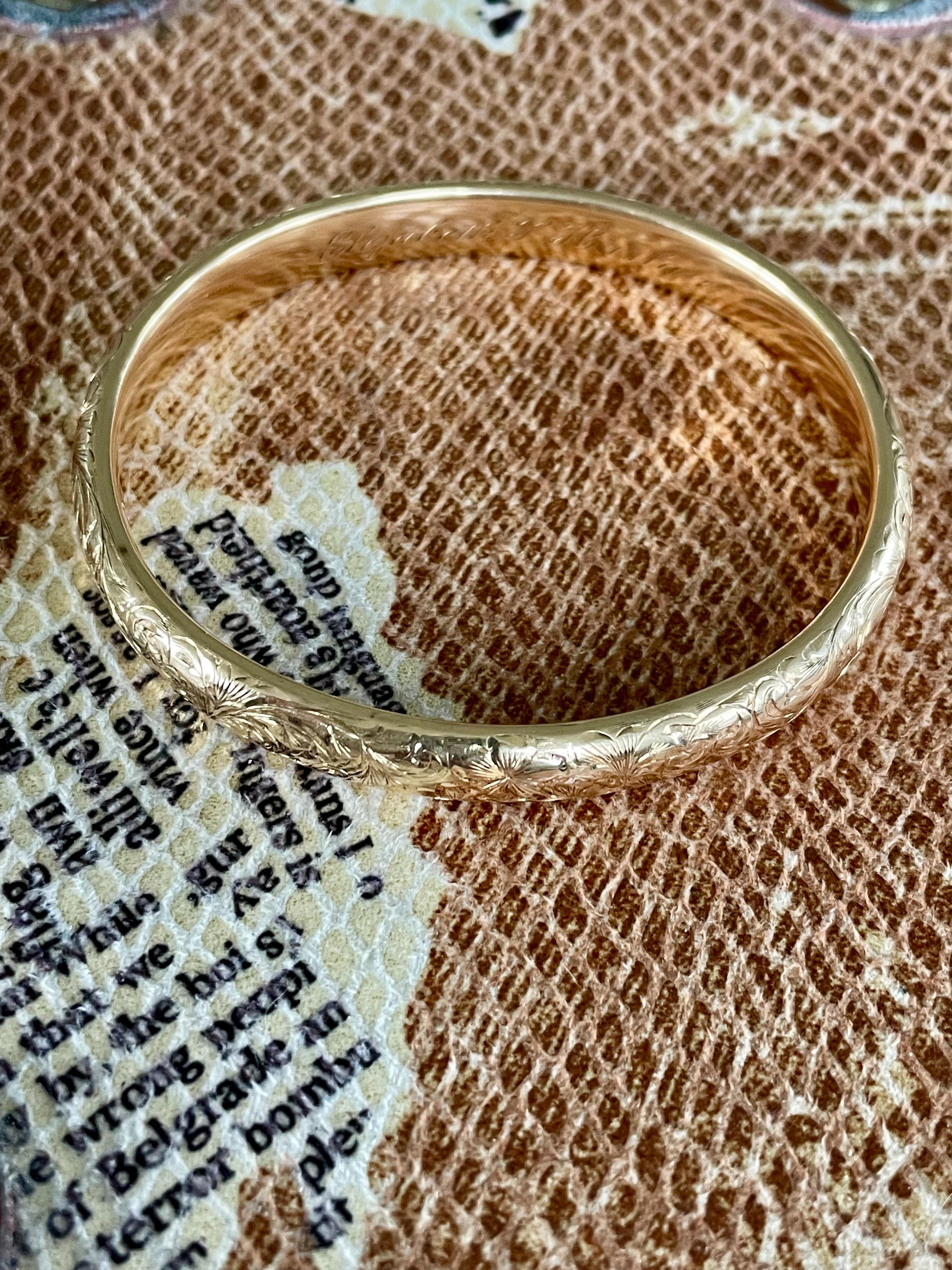 This beautiful, antique, 14 karat yellow Gold bangle is Art Nouveau.  It features lovely floral engraving encircling the entire circumference of the bangle.  

The inside is engraved:  Elizabeth S. Harlan

Stamped: WAB:  Wordley Allsopp &