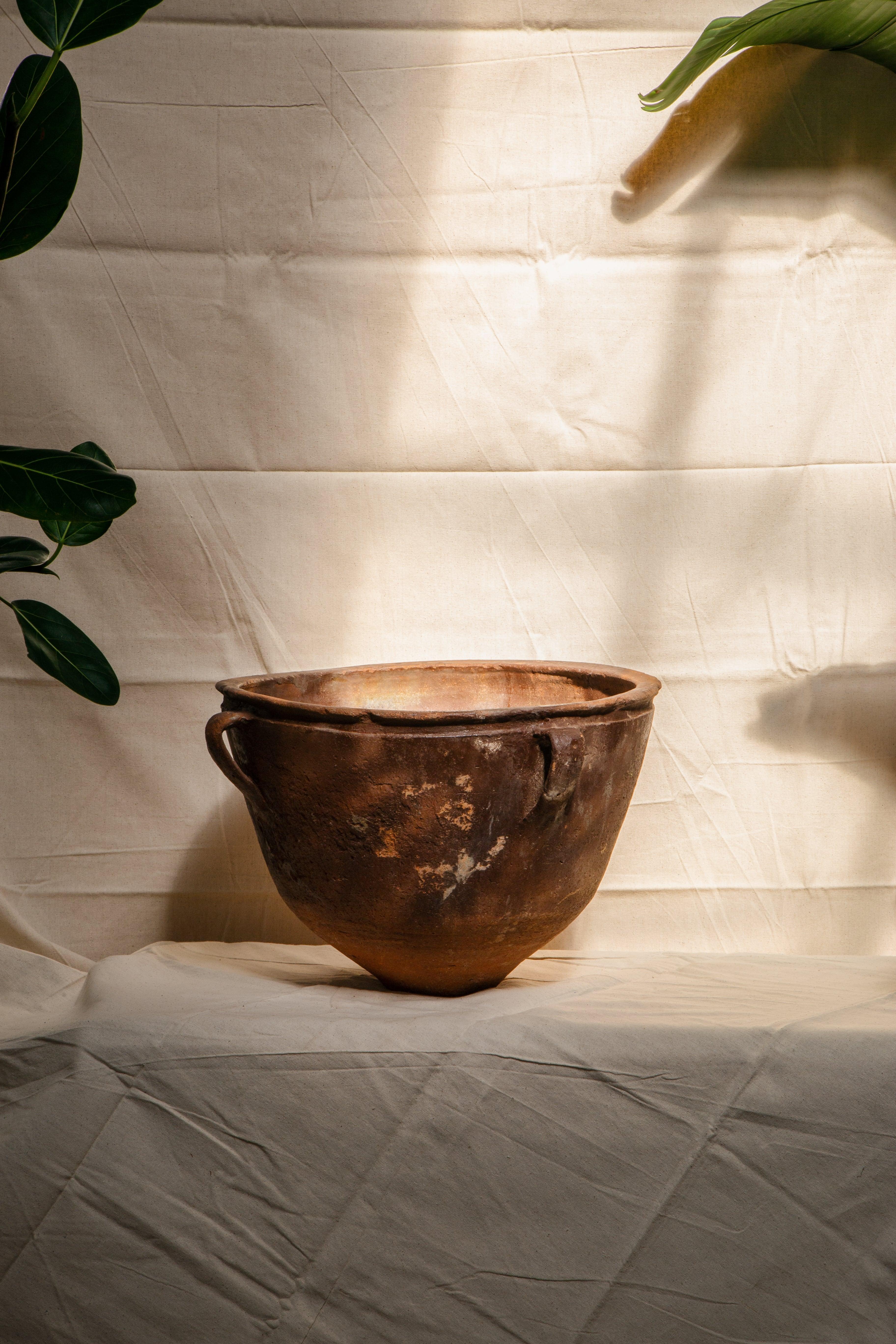 Das Antique Artisan Clay Vessel ist ein bemerkenswertes Gefäß, das tiefe, erdige Töne mit einem Hauch von Geheimnis verbindet. Dieses mit exquisiter Kunstfertigkeit gefertigte Gefäß verkörpert die Essenz antiker Töpferkunst und strahlt einen tiefen
