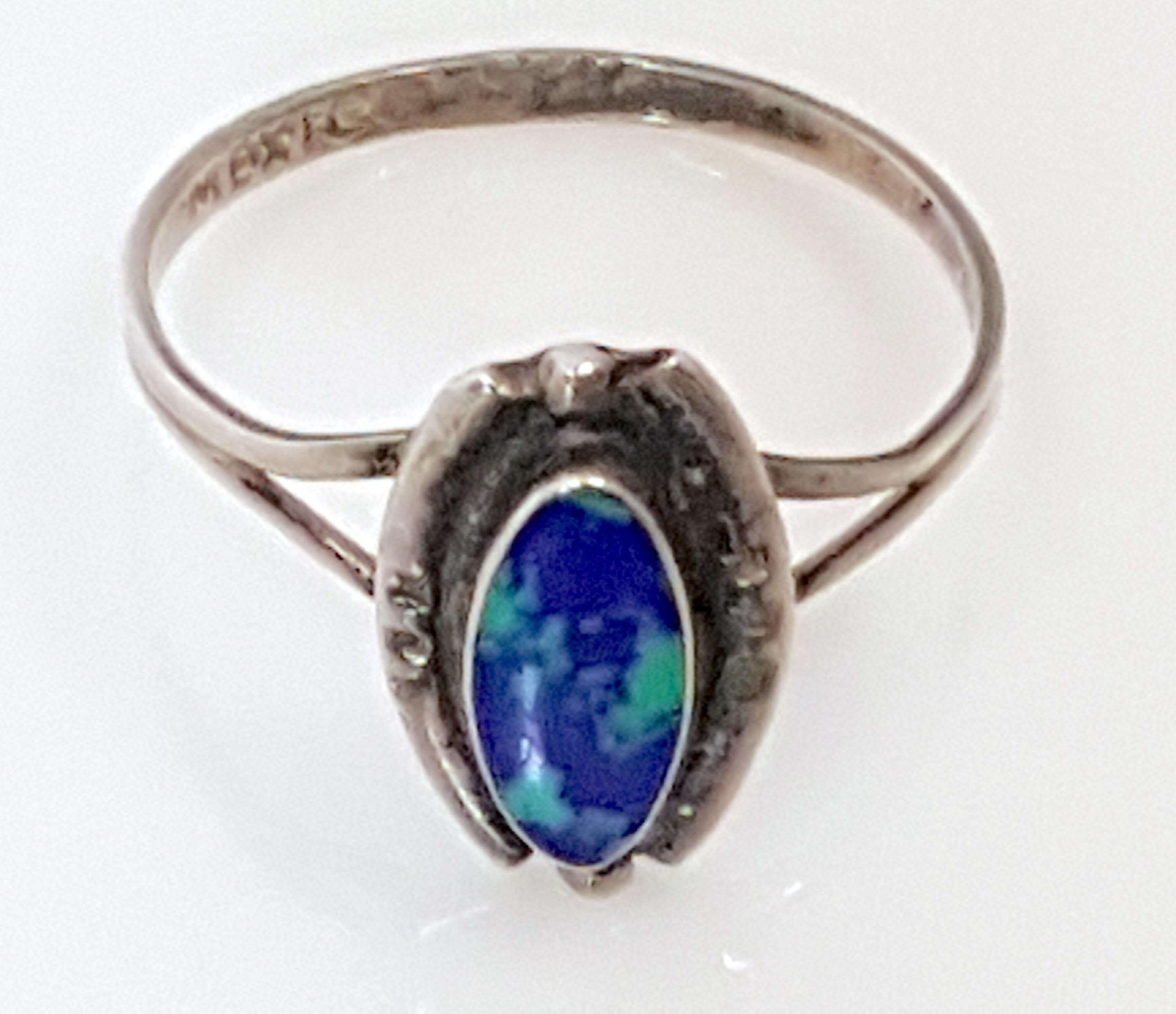 First appearing like an intense green-blue black opal without the flash, this antique natural azurmalachite oval-cut 10mm cabochon in a bezel setting features curvaceous vivid-green malachite clusters without striation pseudomorphed among
