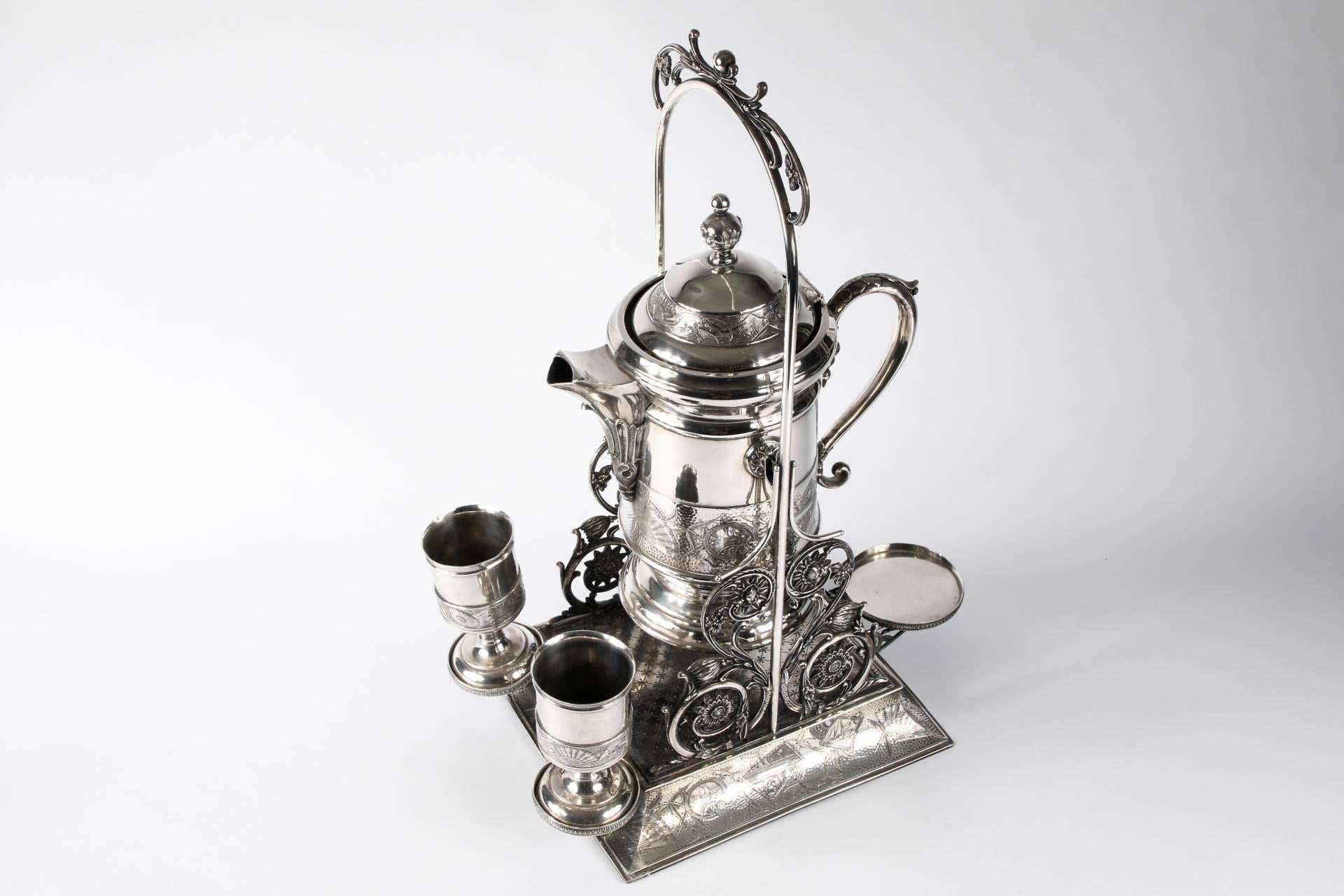 Antique Arts & Crafts silver plate beverage dispenser on stand with cups, by the Hartford silver plate Co., CT, large tilting beverage dispenser on stand, all decorated with bands of Japanese inspired decoration, Stand with openwork scrolled floral