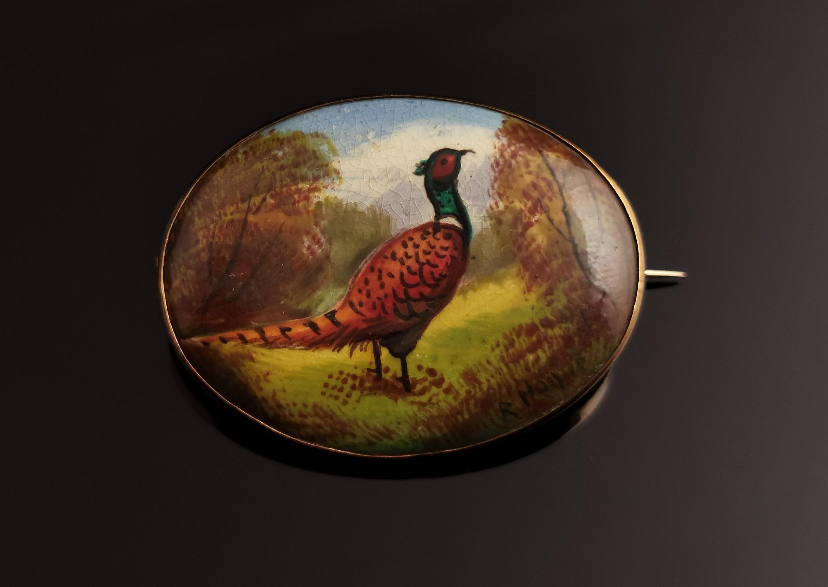 A rare antique early 20th century Minton brooch painted and enamelled by Reuben Hague.

The brooch is made from ceramic and has been finely hand enamelled with a pheasant in a wood.

This highly detailed and beautiful piece is set into a gilt bezel