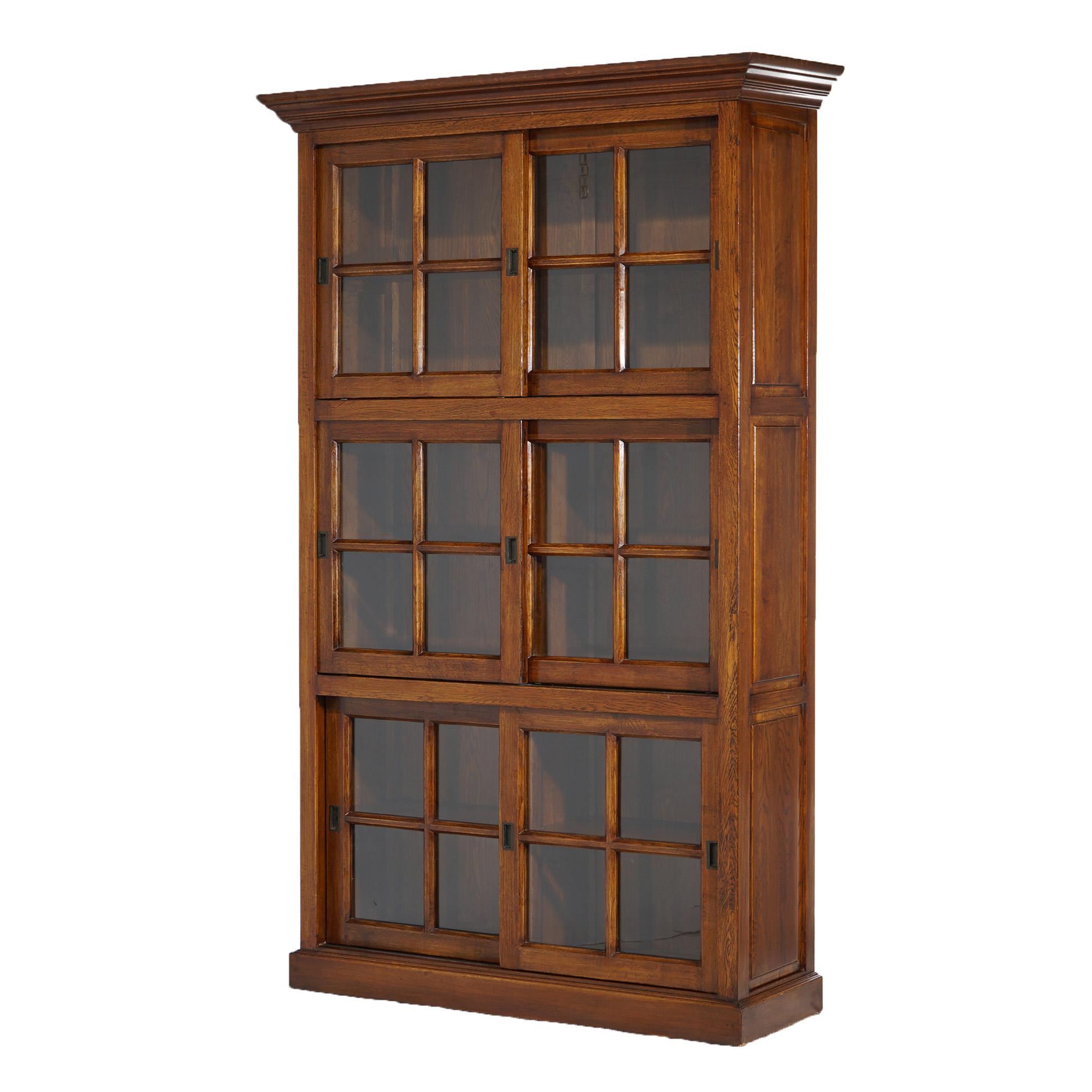 An antique Arts and Crafts Mission barrister style bookcase offers quarter sawn oak construction with three sections, each having sliding glass doors opening to divided and shelved compartments, 20th century

Measures - 85.75