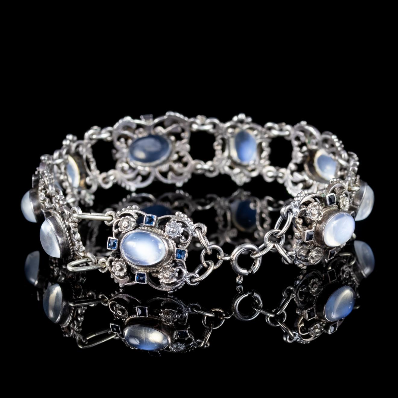 A beautiful antique Arts and Crafts bracelet decorated with Moonstones and halos of blue Paste Stones. The Arts and Crafts movement advocated a revival of traditional handicrafts in the late 19th century and used romantic, folk decoration with an