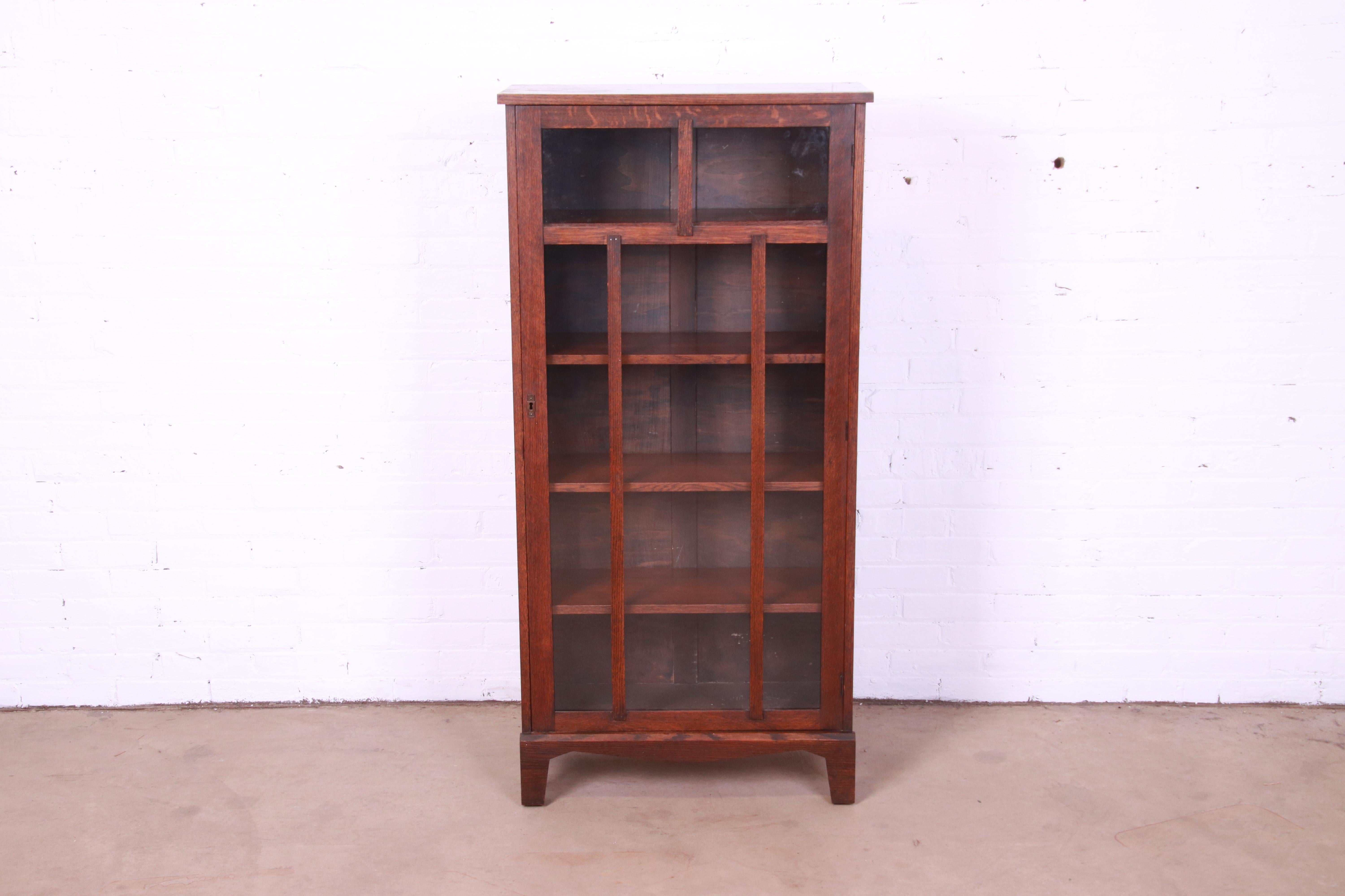 A beautiful antique Arts & Crafts glass front bookcase cabinet

In the manner of Stickley

USA, Circa 1900

Solid oak, with mullioned glass front door.

Measures: 27.5
