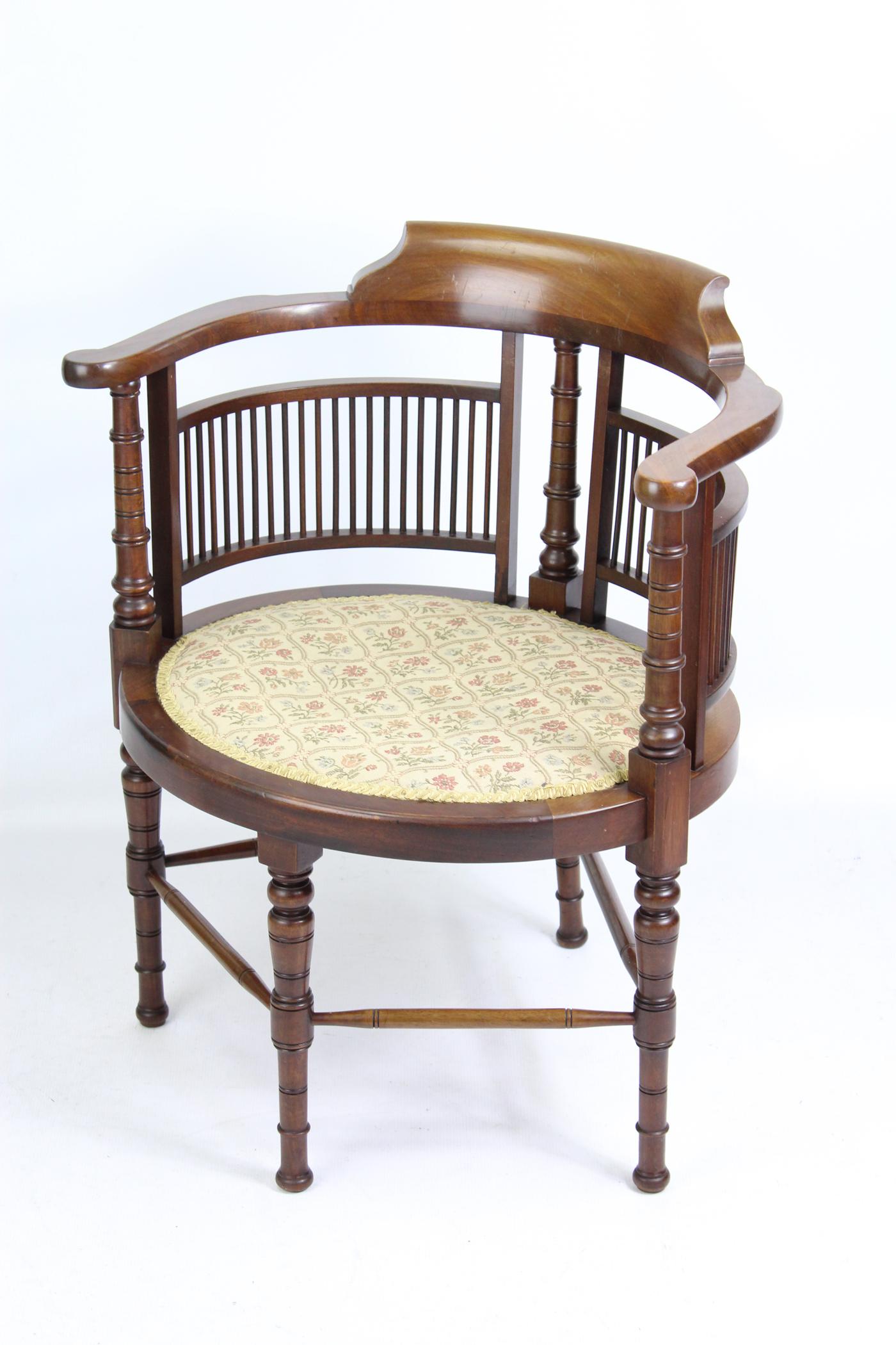 A small charming and unusual antique Arts & Crafts tub chair dating from circa 1900 by Wylie and Lochhead of Glasgow. With spindle back and curved top rail it has turned legs united by cross stretchers. It has an upholstered seat which is in good