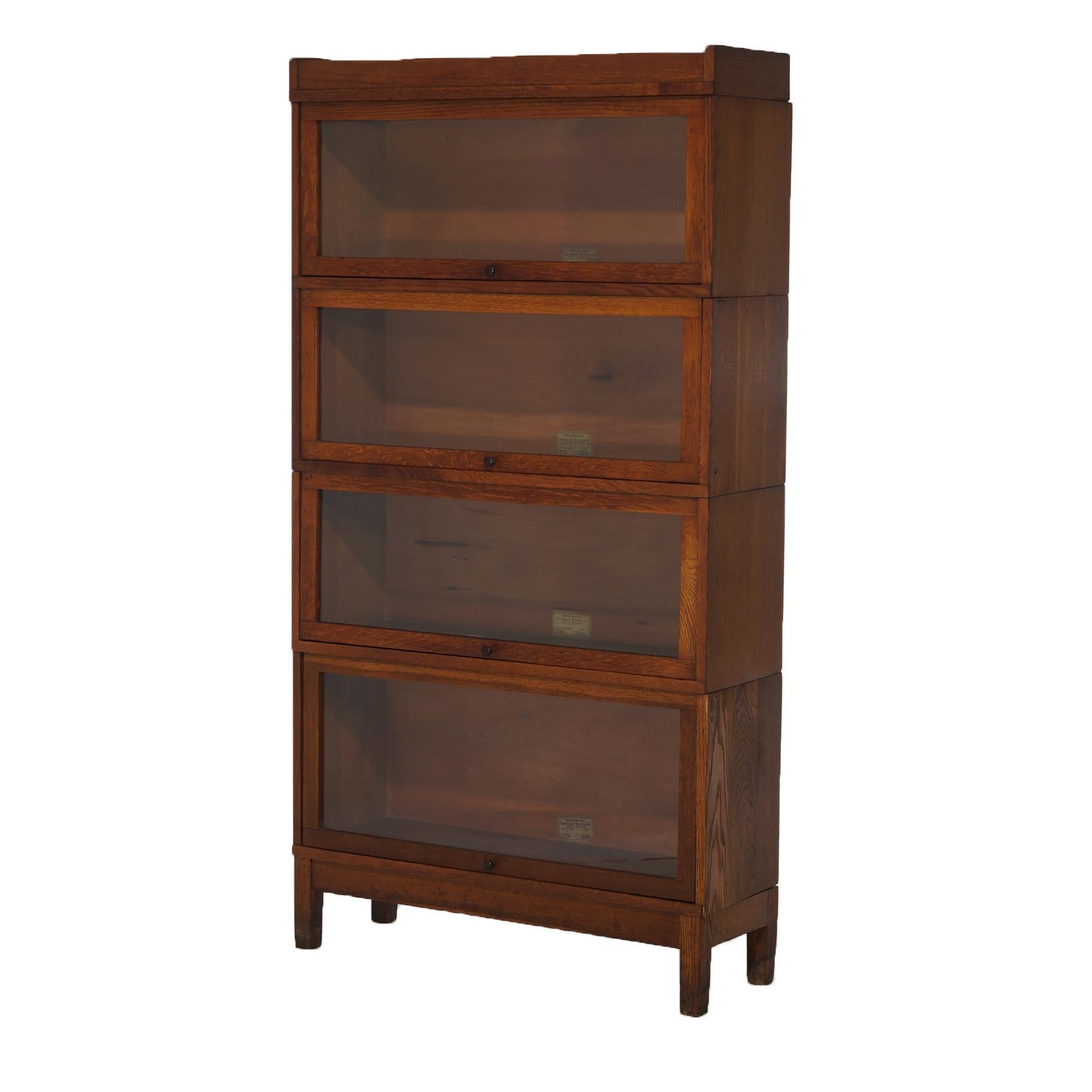 An antique Arts and Crafts Mission barrister bookcase by Globe Wernicke offers quarter sawn oak construction with four stacks, each having pullout glass doors and raised on square straight legs, maker label as photographed, c1910

Measures- overall