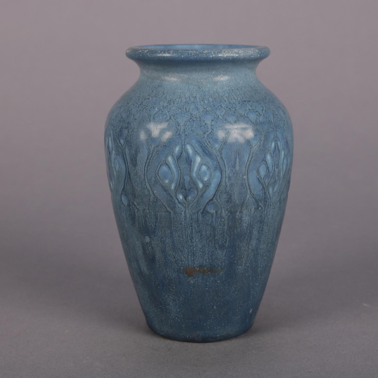 Antique Arts & Crafts art pottery vase by Rookwood Pottery features petite open urn form with stylized foliate glaze design in blues, marked on base, circa 1921.

Measures: 5