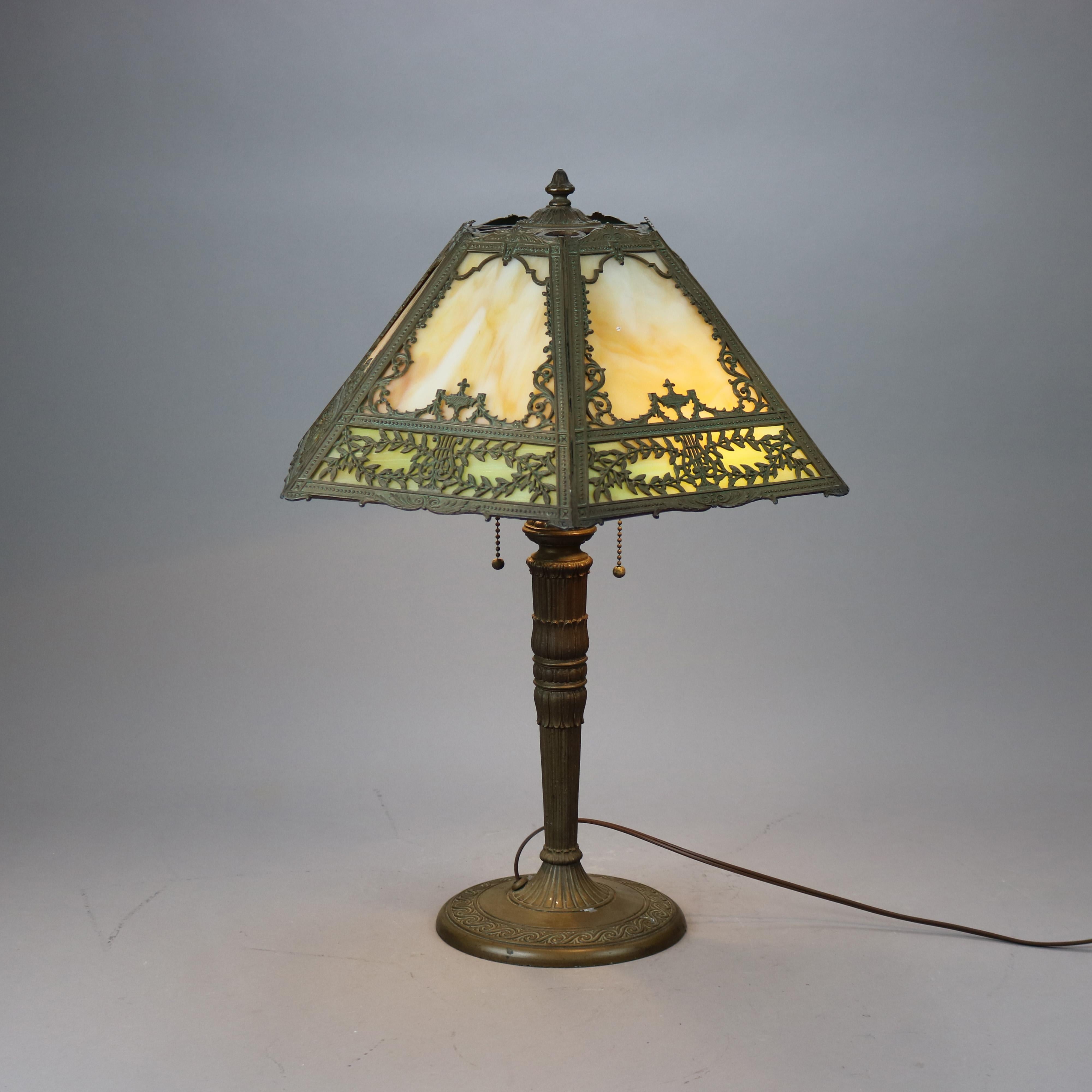 An antique Arts & Crafts table lamp in the manner of Bradley and Hubbard offers cast filigree shade housing slag glass panels on cast double socket base, c1920

Measures - 22.75'' H x 18'' W x 18'' D.
